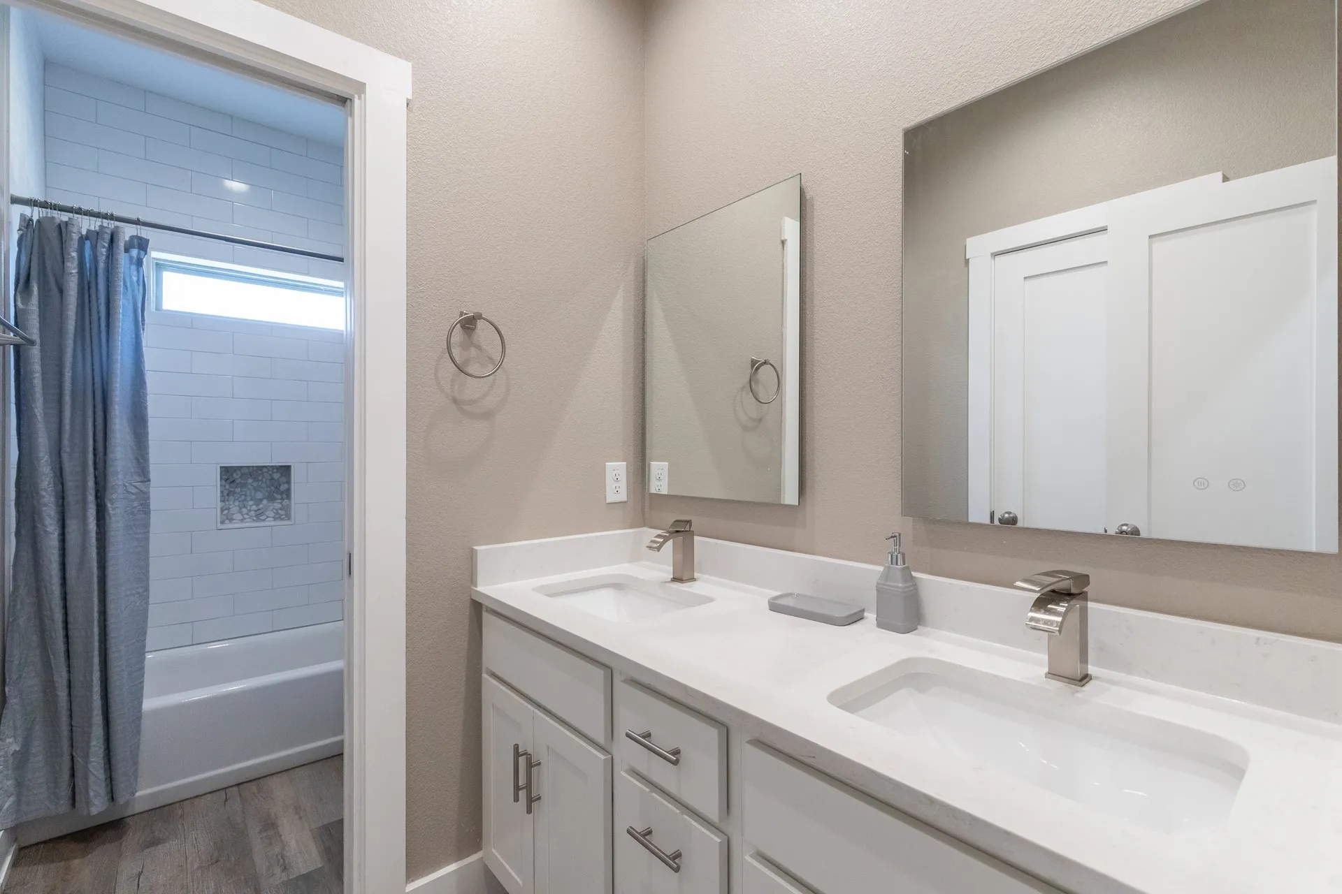 Double vanity with integrated sinks, quartz countertops, and brushed nickel fixtures