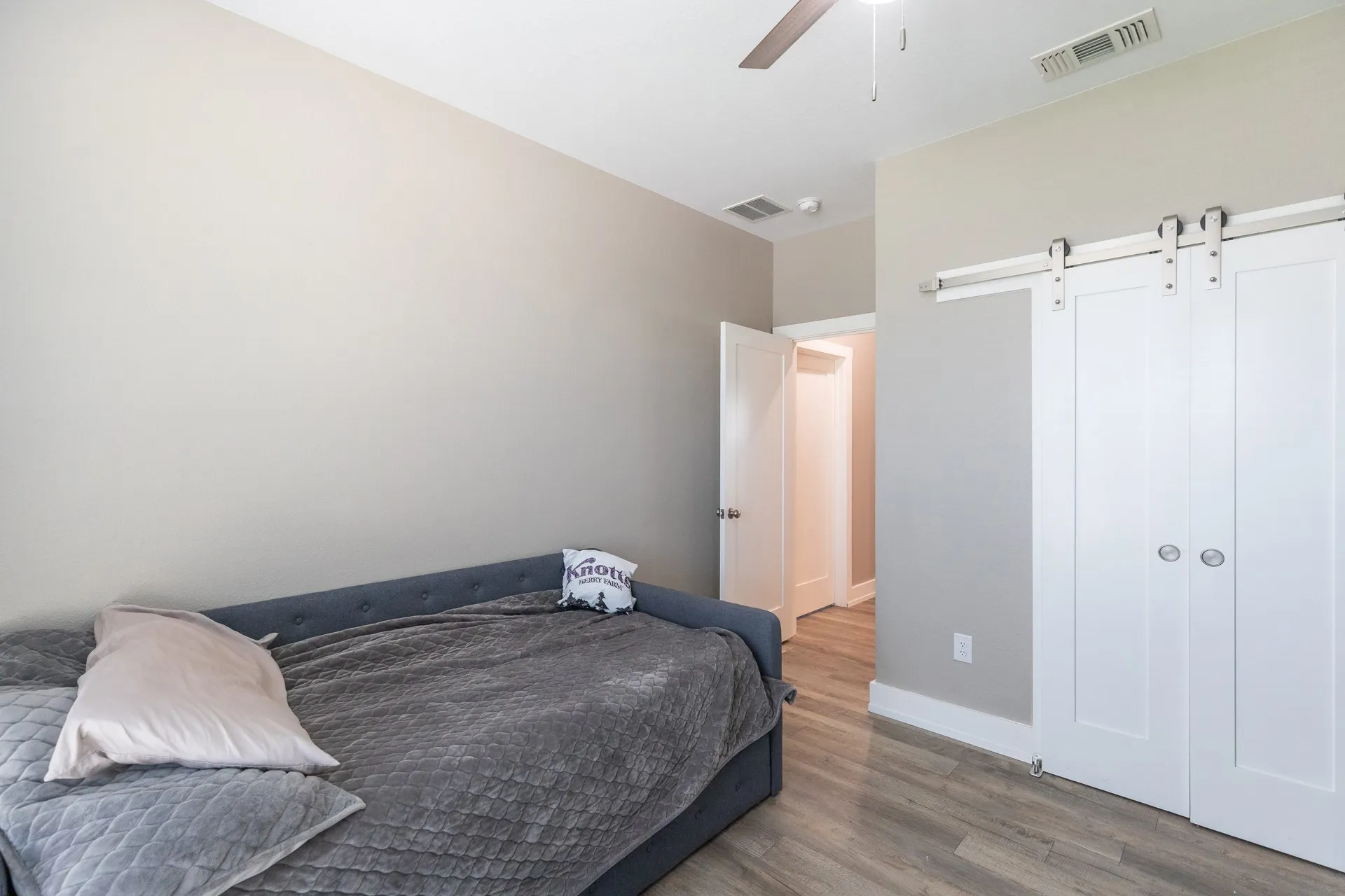 Bedroom featuring wood-finish flooring, neutral wall tones, and a ceiling fan