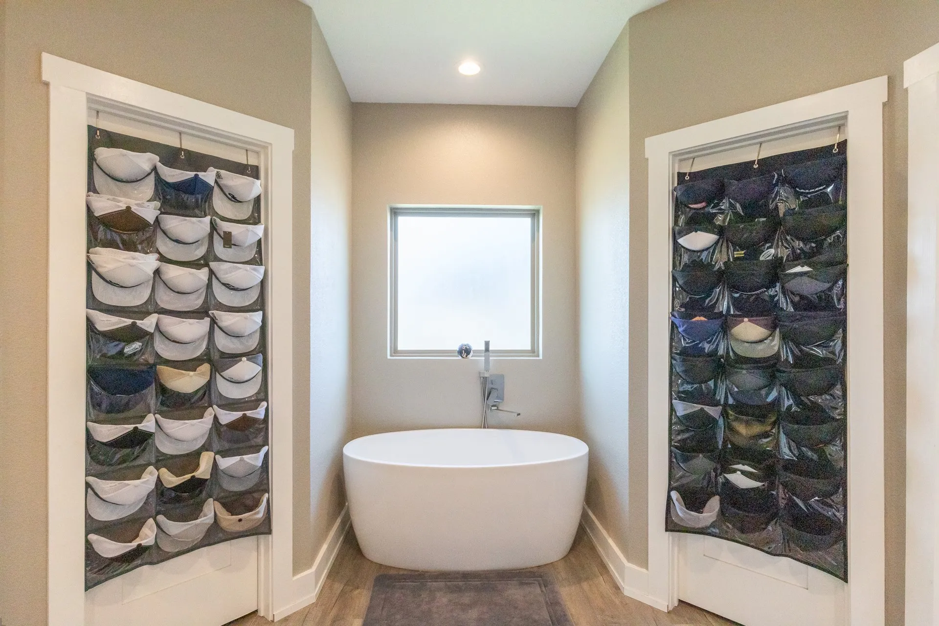 Freestanding soaking tub with a frosted window and wall-mounted faucet