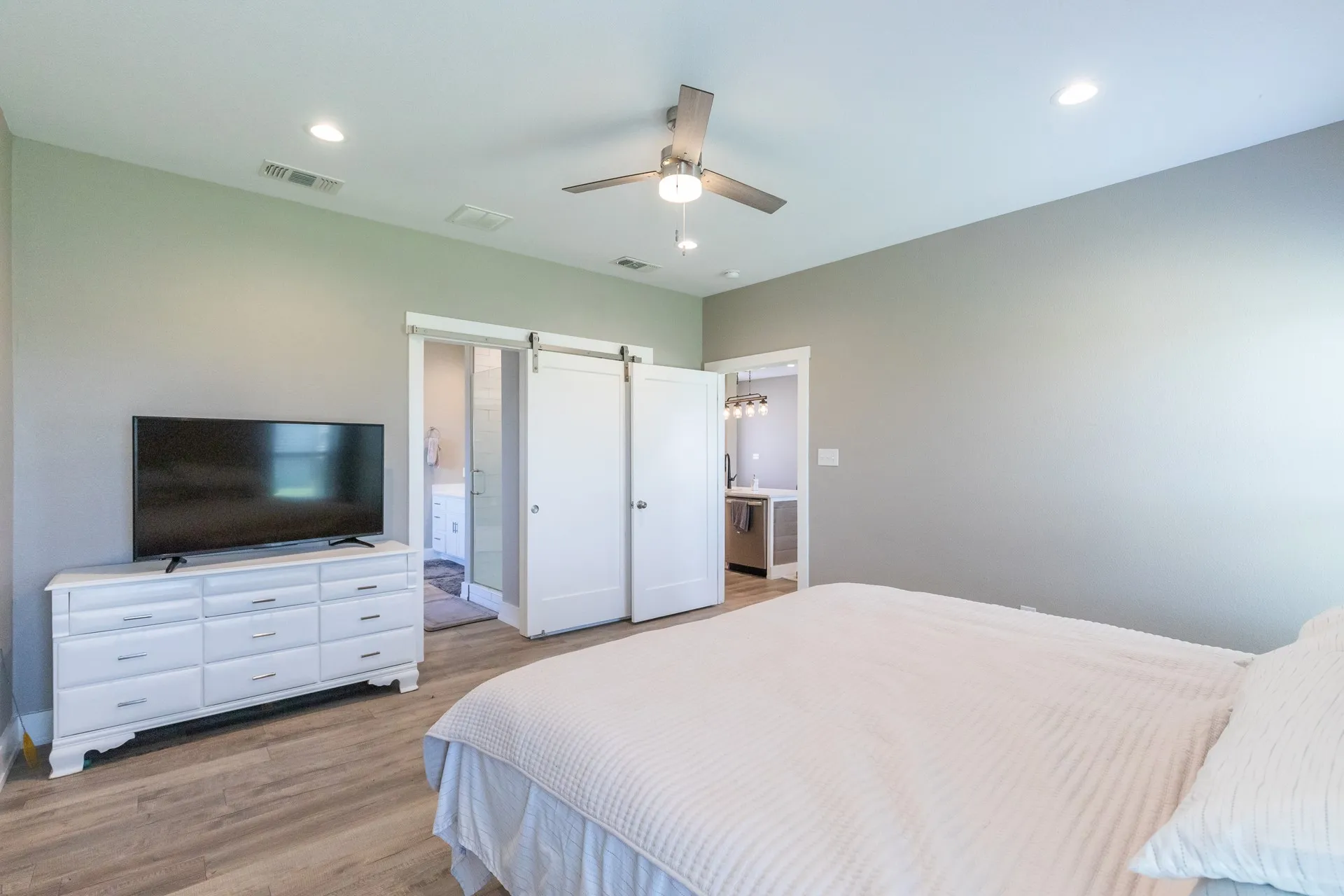 Spacious room featuring wood-finish flooring, recessed lighting, and a ceiling fan