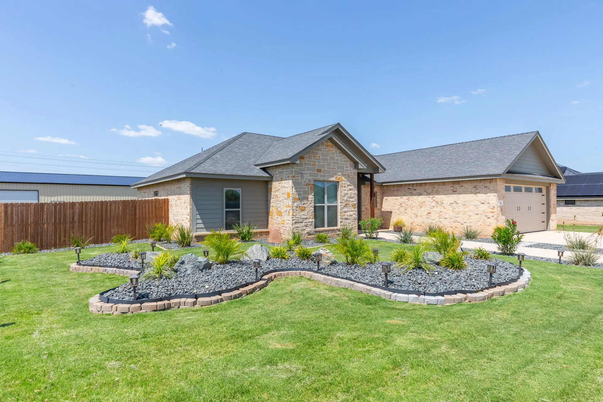Stone and siding exterior with a dark gray asphalt shingle roof