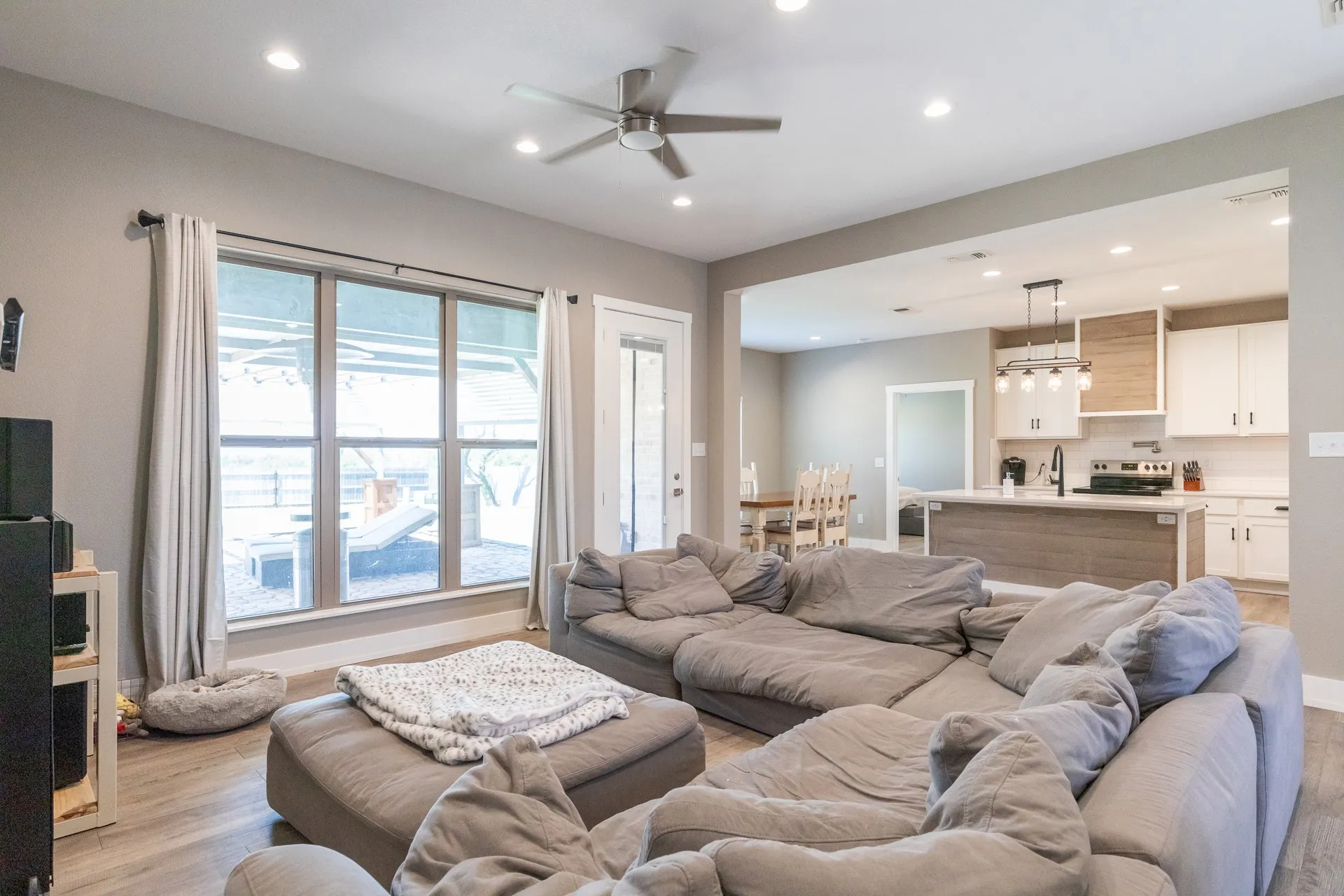 Spacious living area featuring wood-finish flooring, recessed lighting, and a ceiling fan