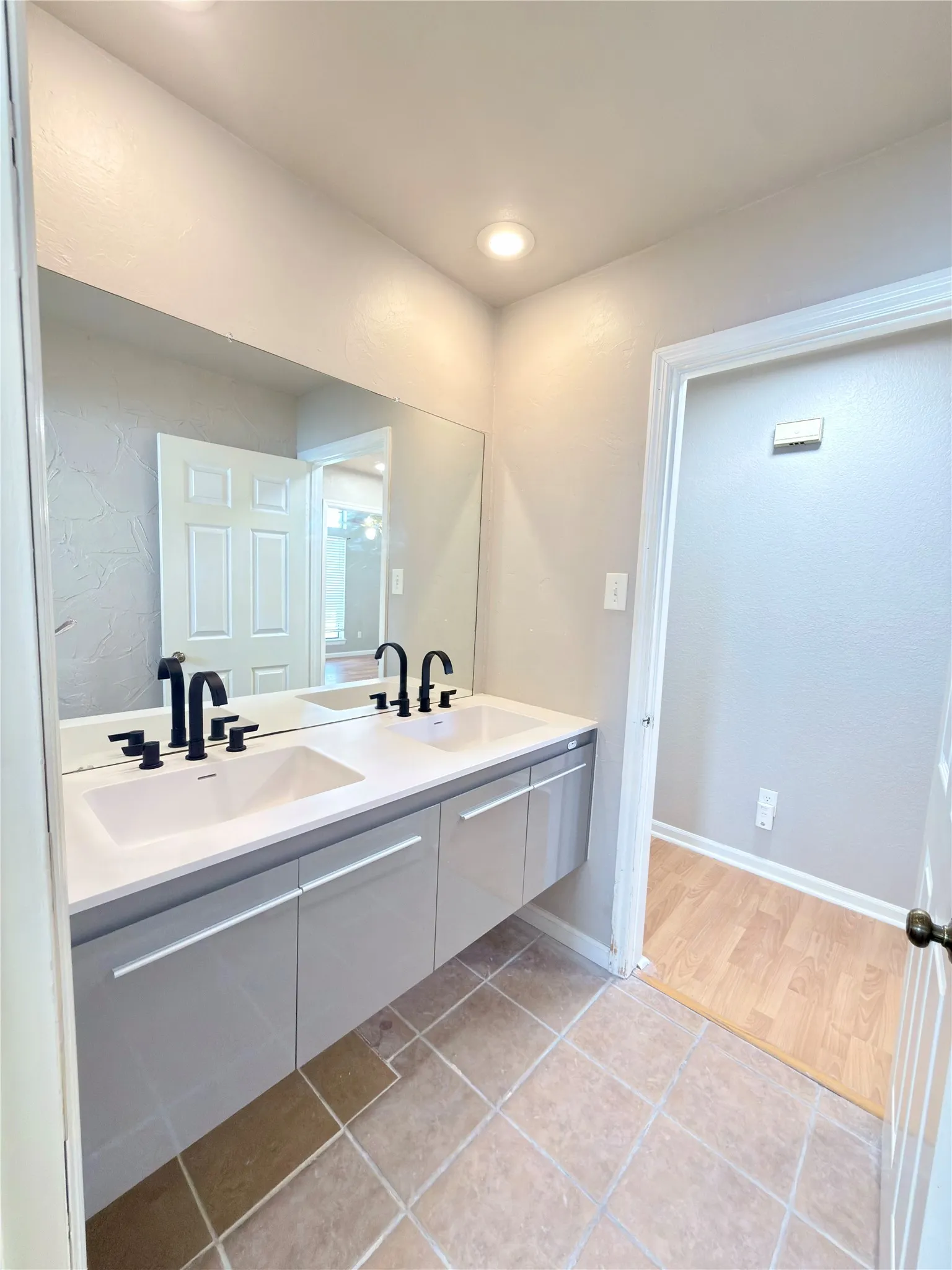 Dual floating vanity with rectangular sinks, matte black fixtures, and integrated storage
