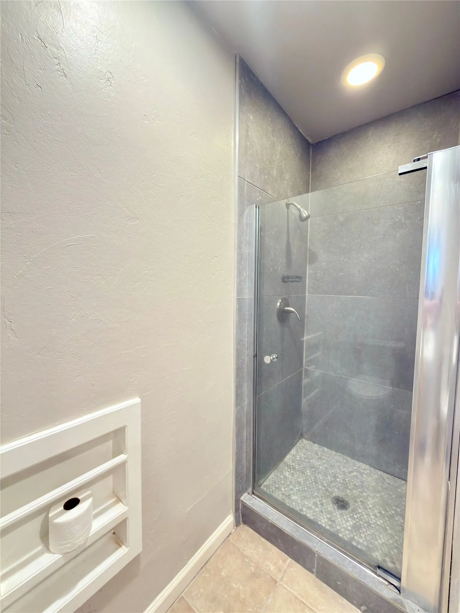 Enclosed shower with full-height tile surround and glass door