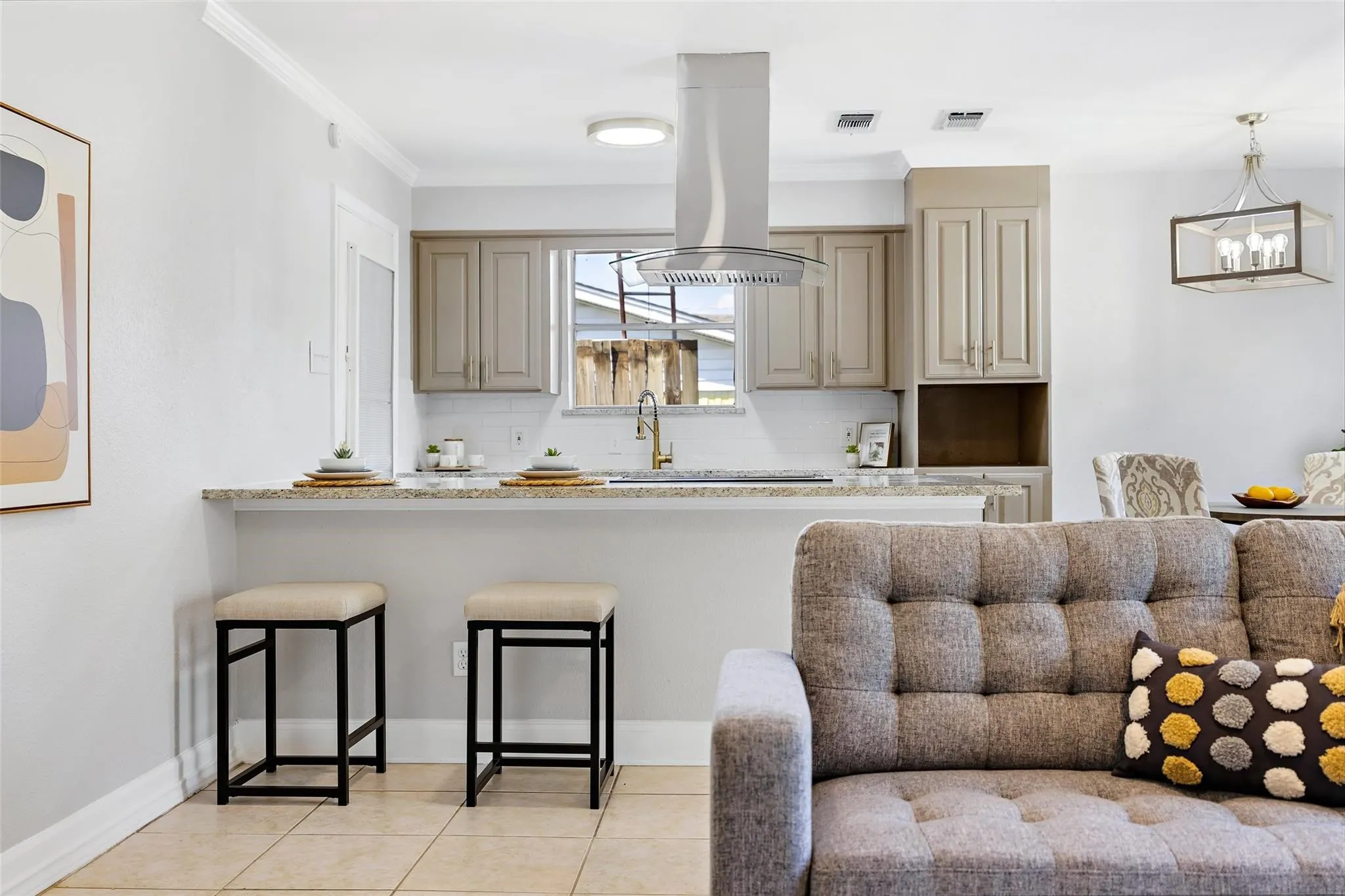 Kitchen featuring a light-toned  virtual stagedbacksplash, granite-style countertops, stainless steel vent hood, and upper cabinetry