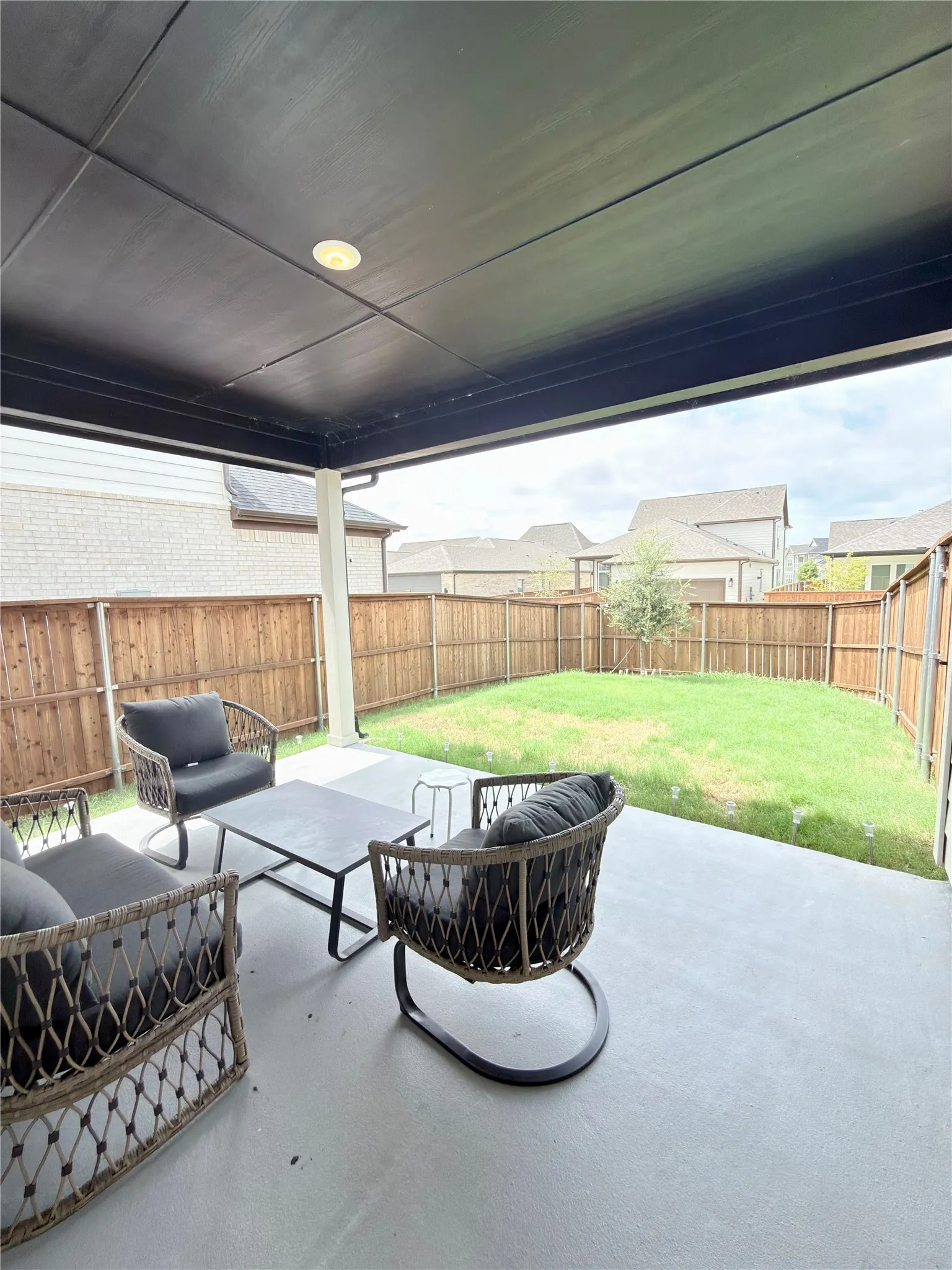Covered patio with a flat black ceiling, recessed lighting, and a concrete slab