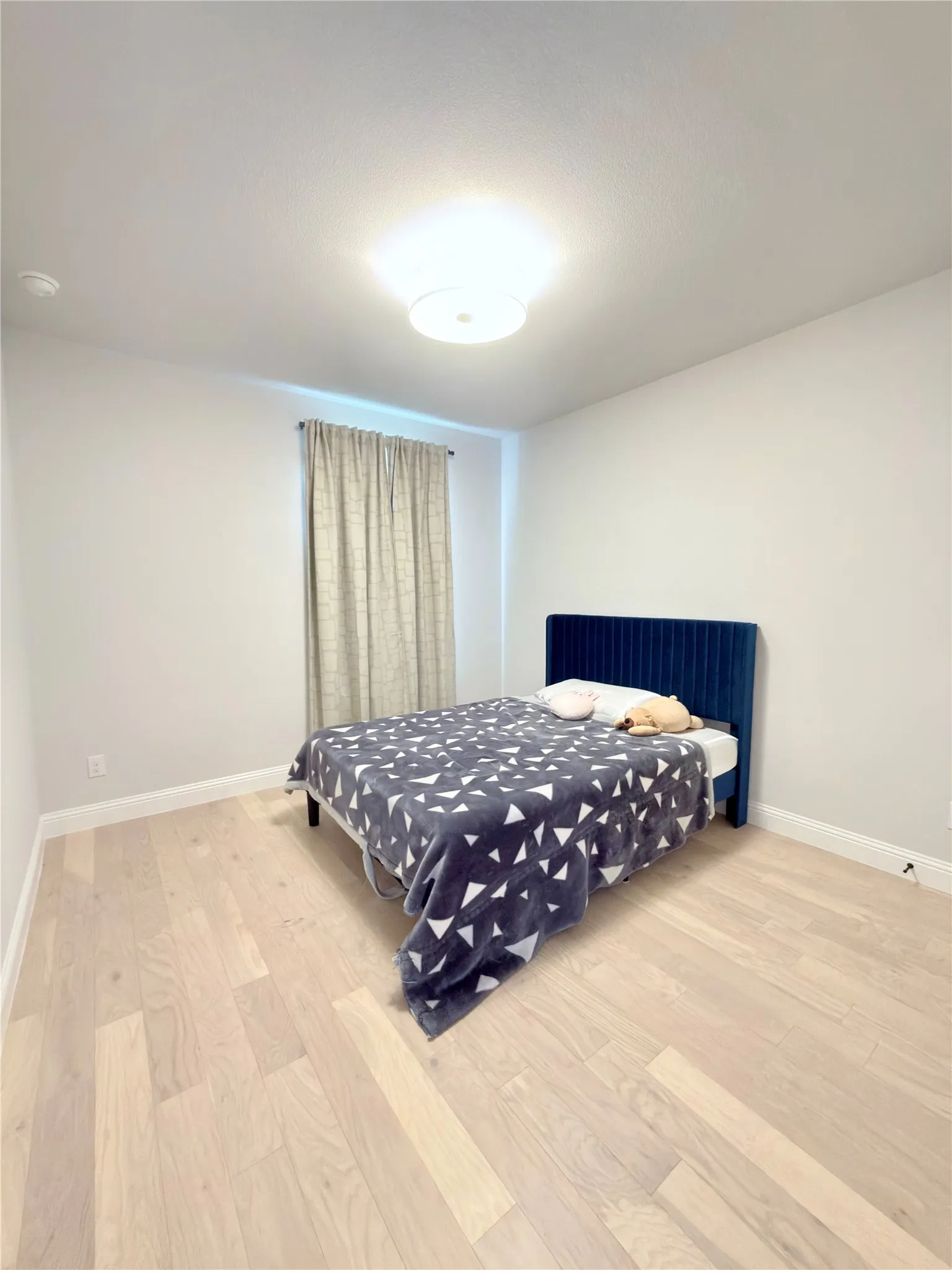 Light-toned wood-finish flooring complements neutral wall tones and white baseboards