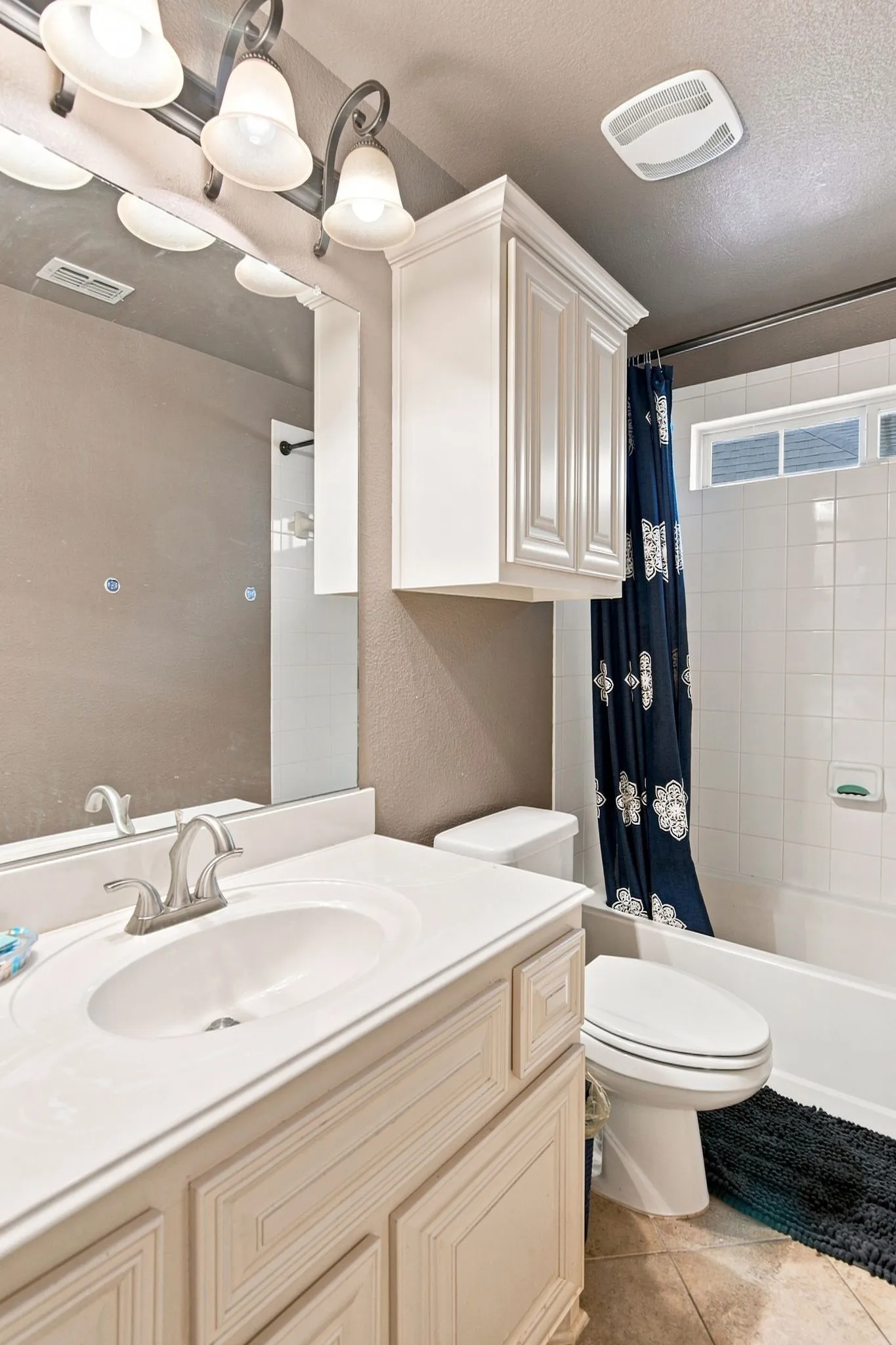 Bathroom vanity with an integrated sink, brushed nickel faucet, and a large wall mirror