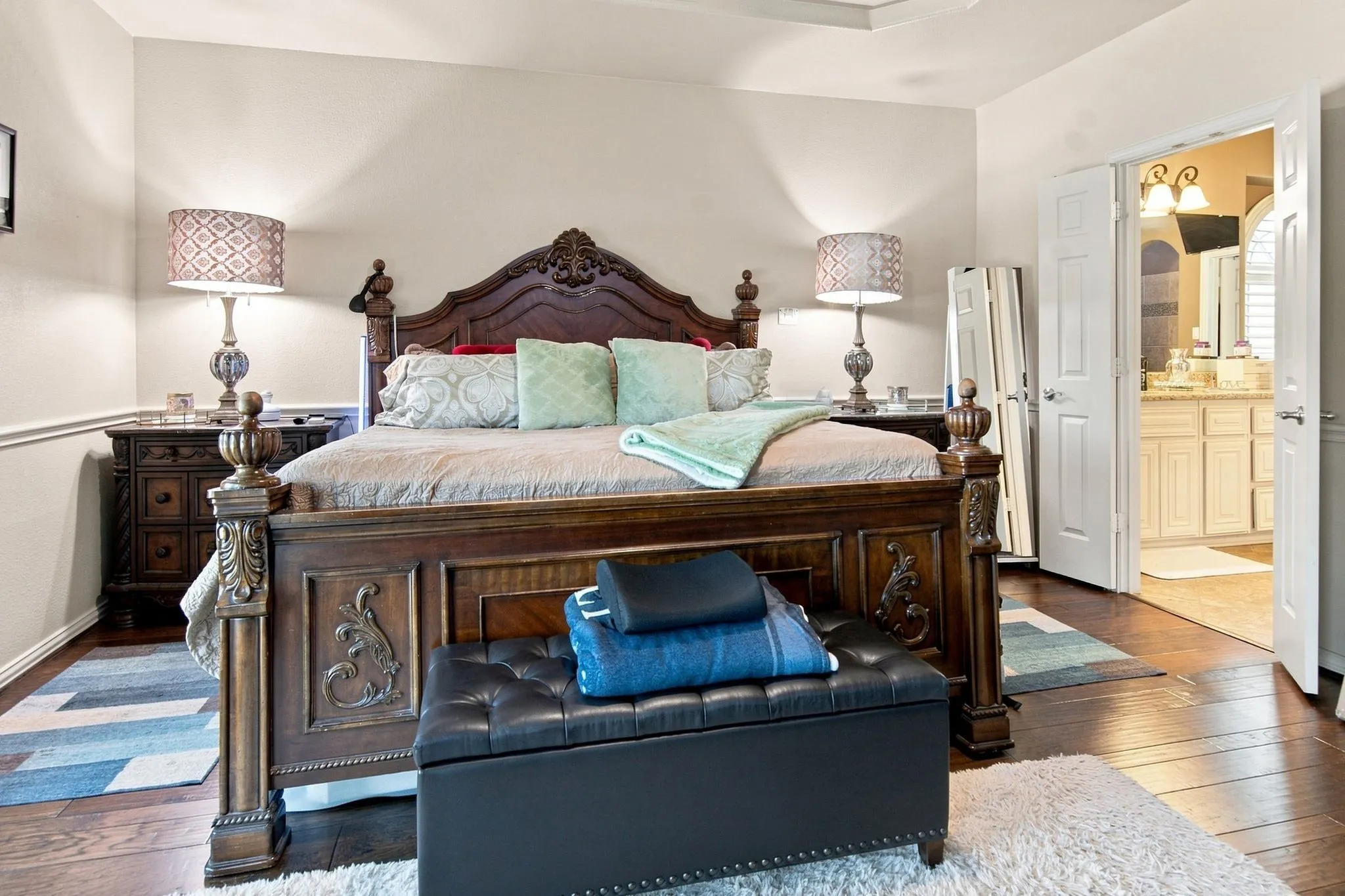 Spacious bedroom featuring wood-finish flooring, white baseboards, and crown molding