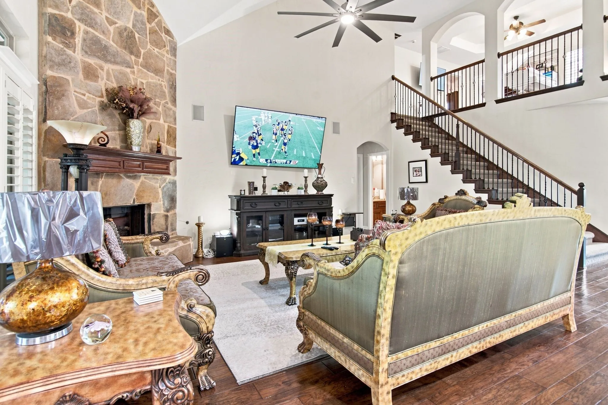 Spacious living area featuring a vaulted ceiling and wood-finish flooring