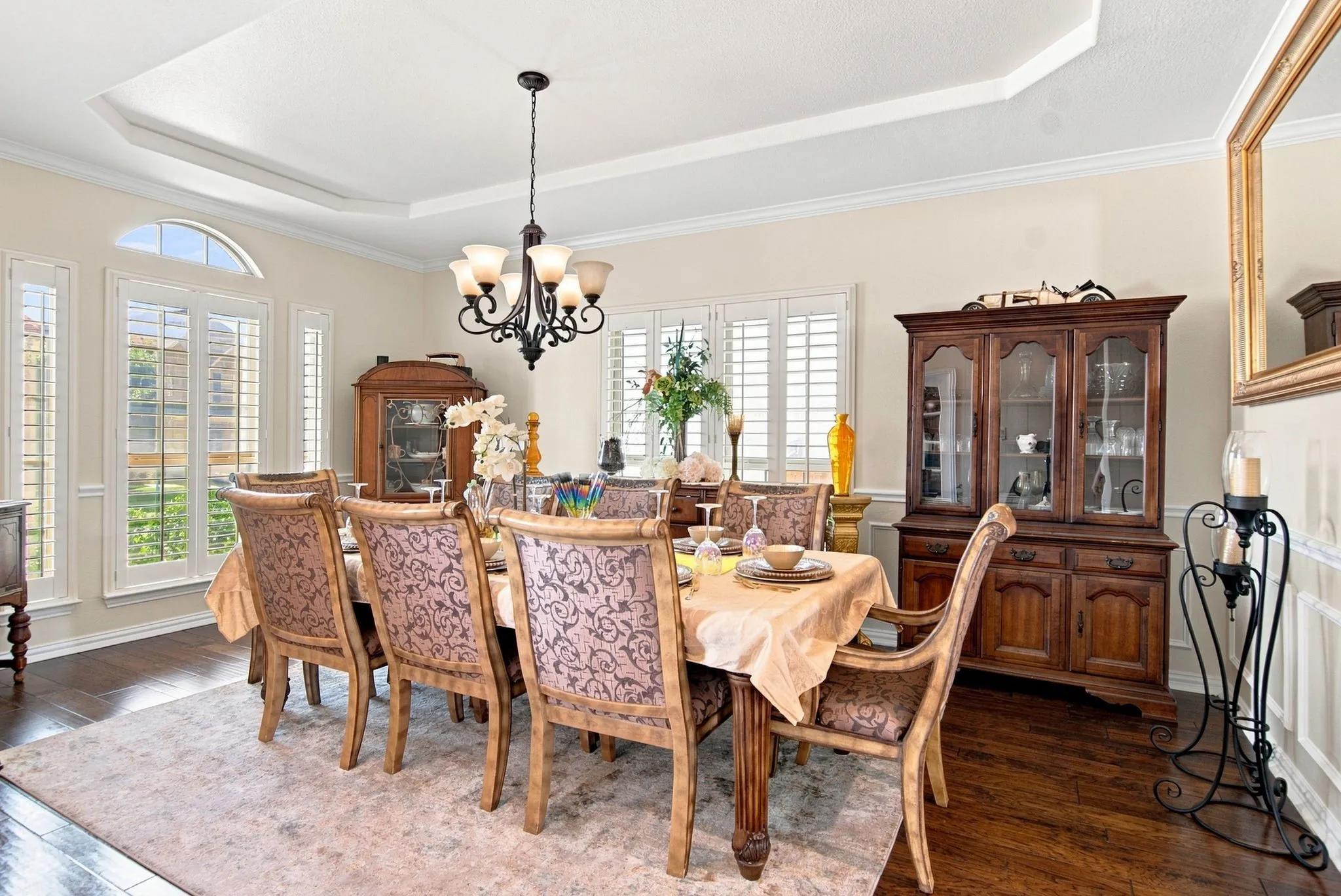 Dining area featuring dark wood-finish flooring, a tray ceiling, and a chandelier