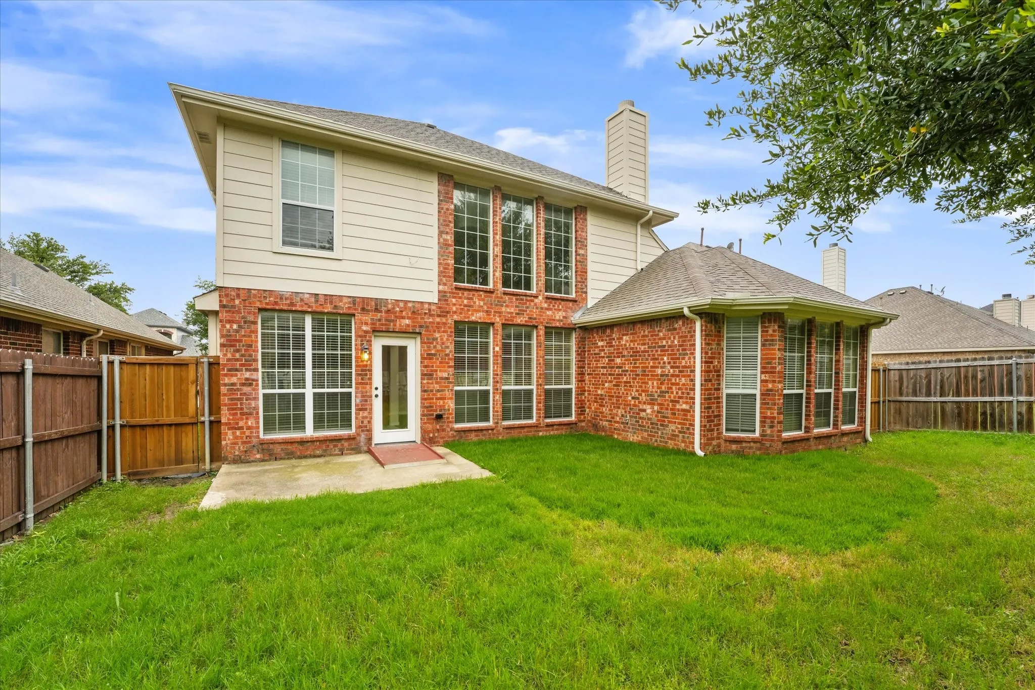 Back of property featuring a patio area and a lawn