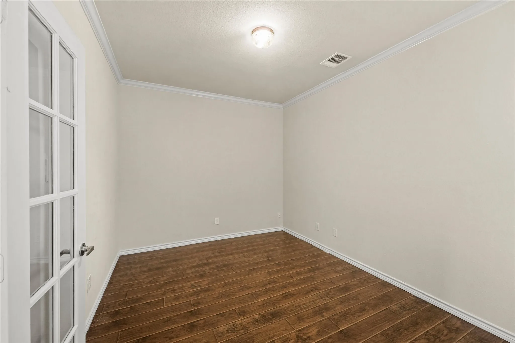 Spare room with ornamental molding and dark hardwood / wood-style flooring