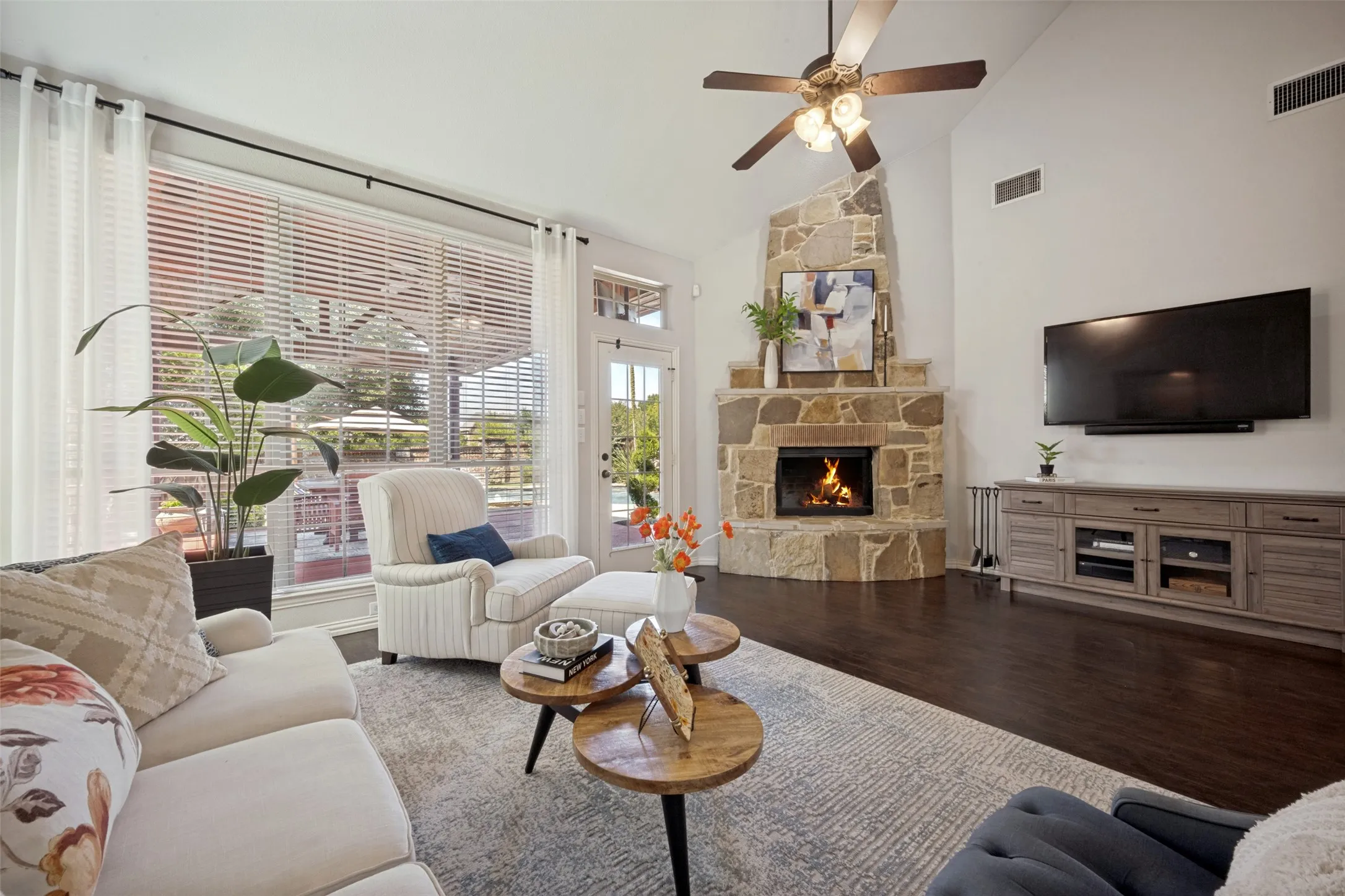spacious living area, with with stone fireplace, floor to ceiling windows that capture the beautiful views from the outdoor oasis with beautful custom cabana, outdoor living area, several conversation areas, pool with spa, water falls and water features.