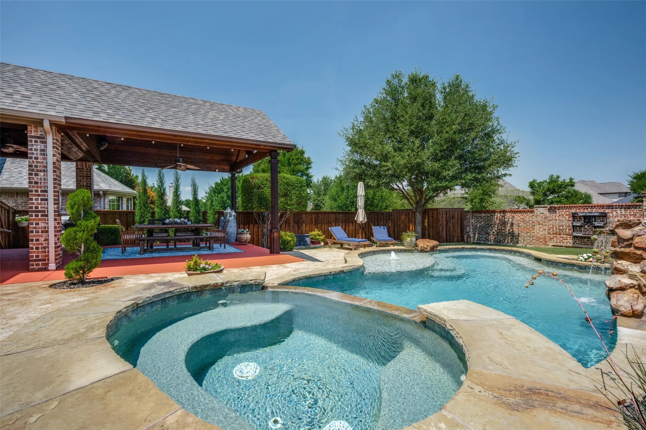 Step into your own private retreat where exceptional outdoor living takes center stage. This stunning backyard showcases a sparkling custom pool with elegant water features, tanning ledge  creating the perfect setting for relaxation and entertaining. The impressive covered cabana, highlighted by the vaulted ceilings, provides a true outdoor living area complete with ample space for dining, lounging, or gathering with family and friends.
Surrounded by lush landscaping, multiple conversation areas, this outdoor sanctuary offers the ultimate blend of comfort and sophistication. Whether enjoying a quiet morning by the pool, hosting summer celebrations, or unwinding beneath the covered patio, every detail has been thoughtfully designed to maximize enjoyment of the outdoor lifestyle.A rare combination of resort-inspired amenities and timeless architectural appeal, this property delivers the perfect combination of both.