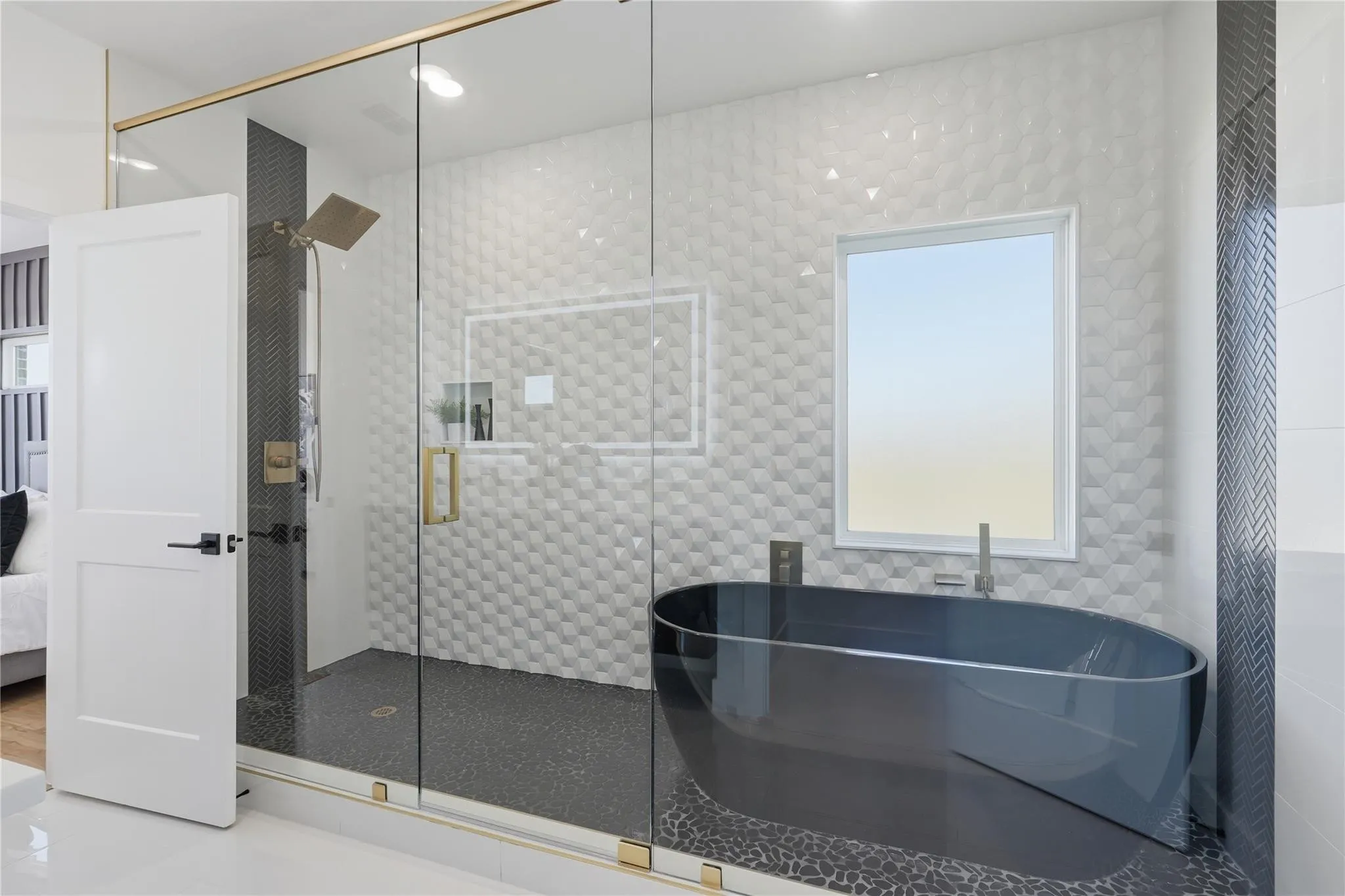 Spacious bathroom featuring a frameless glass shower enclosure with brass-finish hardware