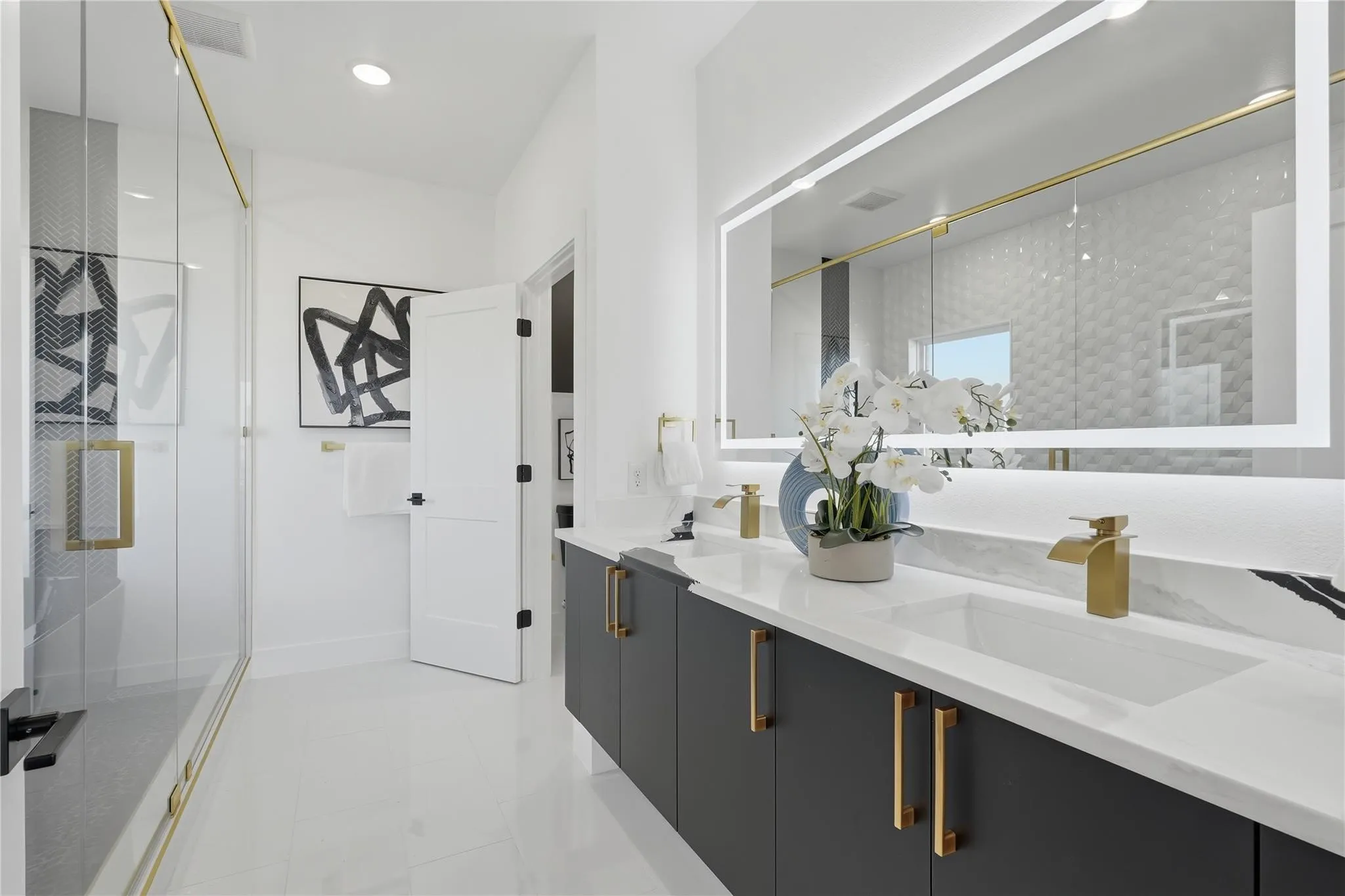 Double vanity with undermount sinks, quartz countertop, and gold-finish fixtures