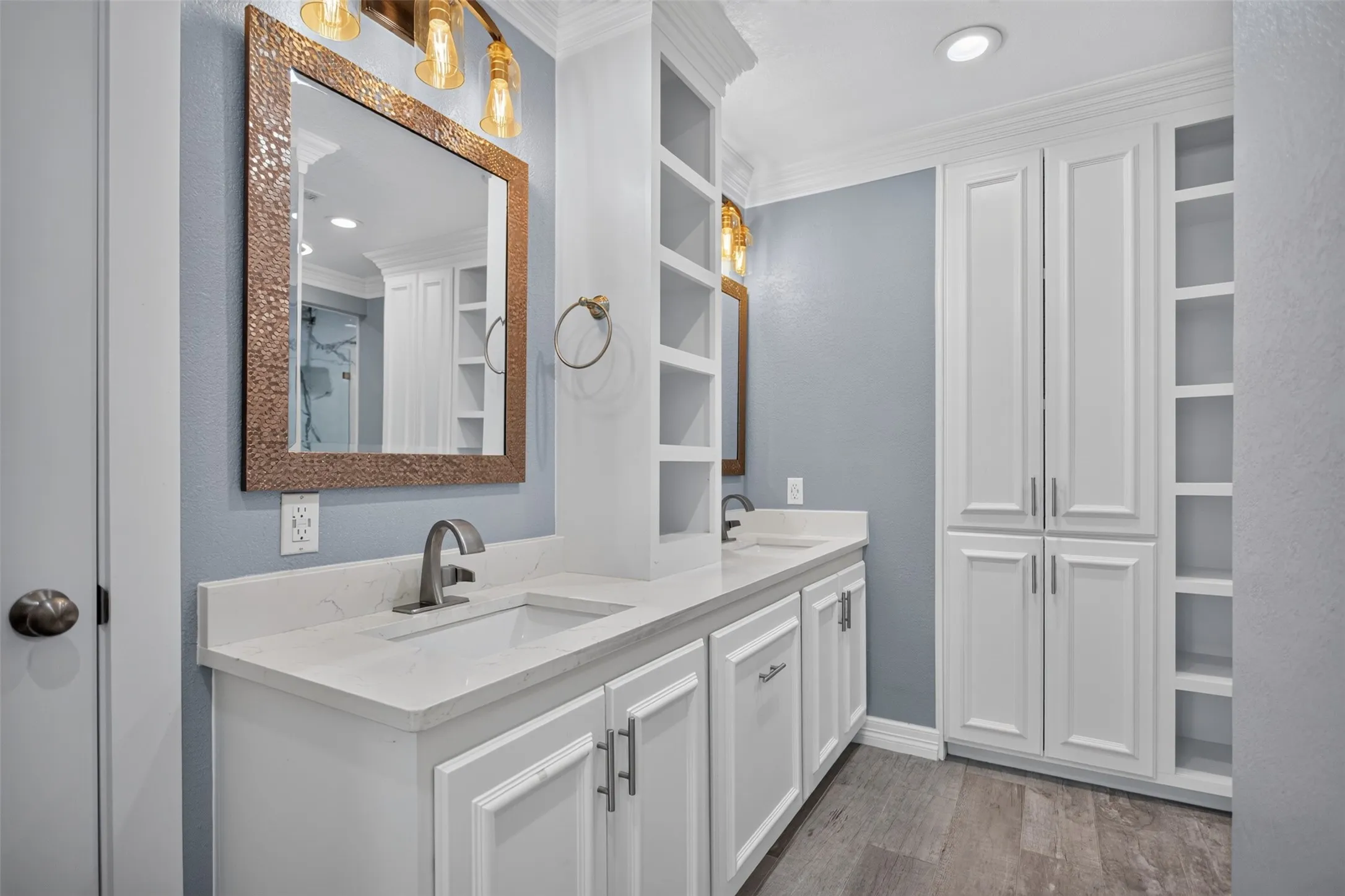 Dual vanity with white cabinetry, light countertops, and brushed nickel hardware