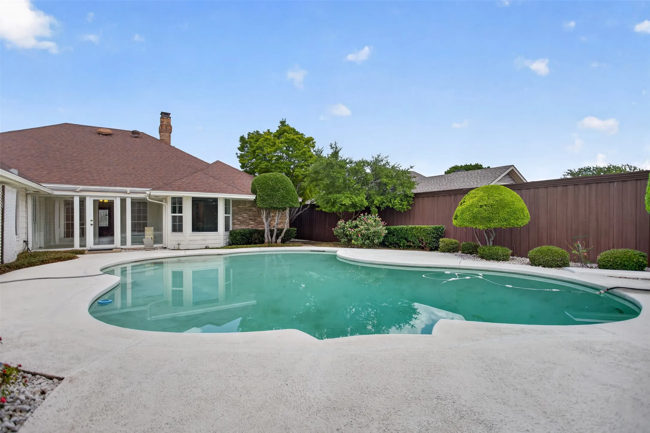 Freeform swimming pool with expansive surrounding patio
