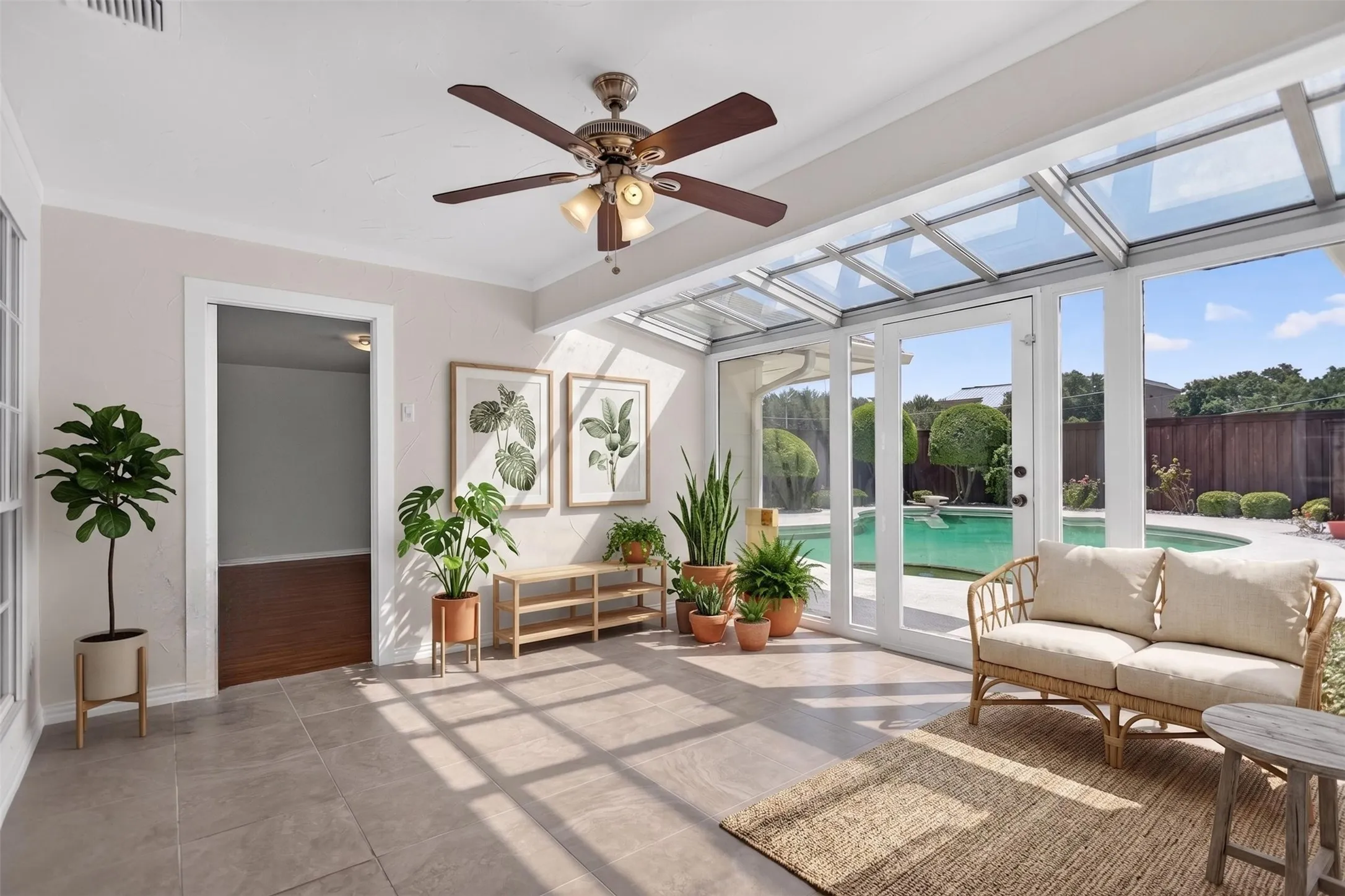 Sunroom featuring a glass-paneled ceiling, transom windows, and full-light French doors opening to a backyard with a swimming pool