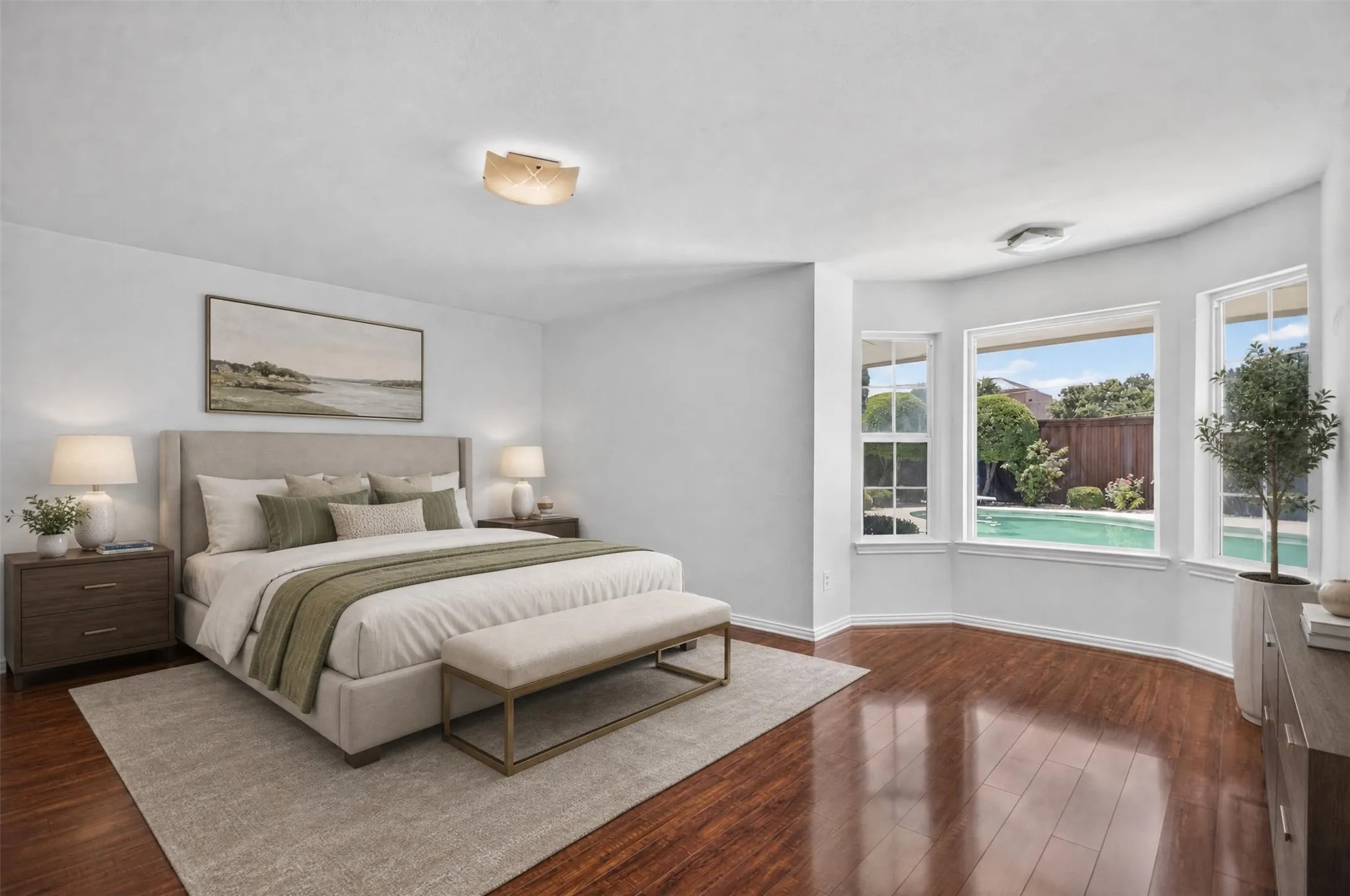 Spacious room featuring wood-finish flooring, a contemporary ceiling light fixture, and a bay window overlooking a private pool