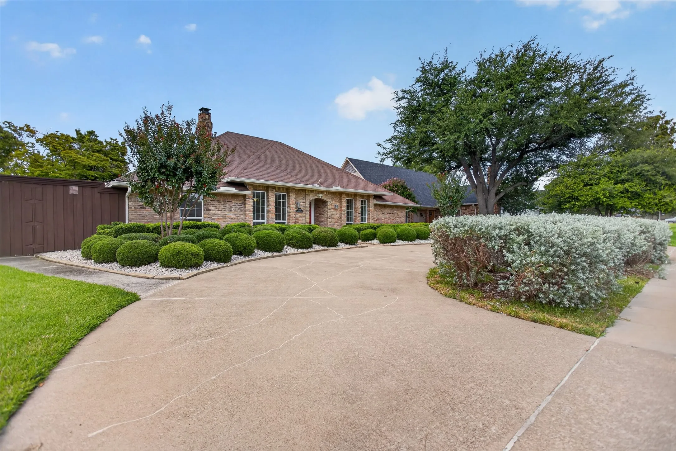 Brick exterior residence featuring a brown shingle roof and a concrete driveway