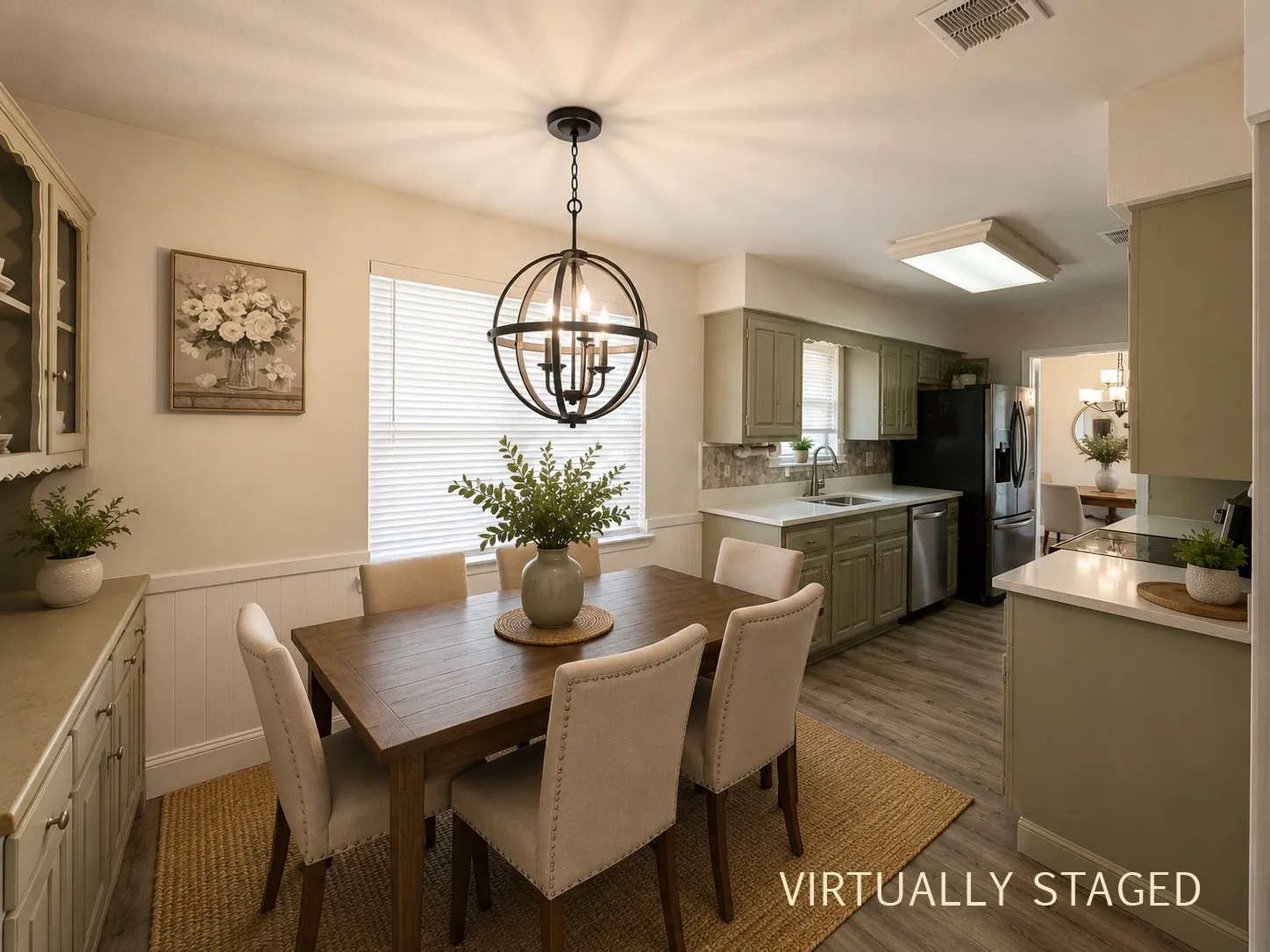 Dining area featuring a contemporary spherical chandelier, wood-finish flooring, and white wainscoting