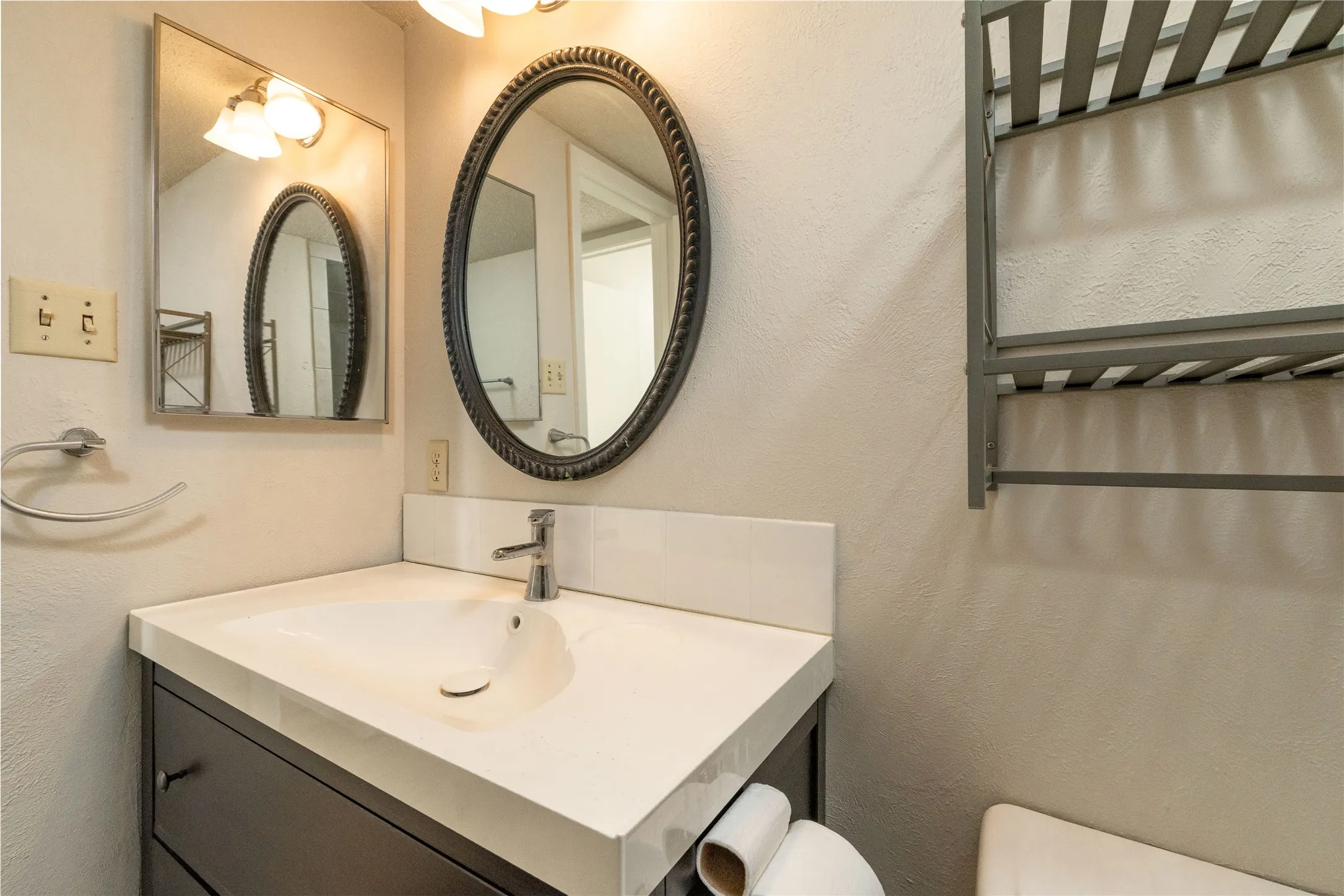 Vanity with an integrated sink, polished chrome faucet, and white countertop