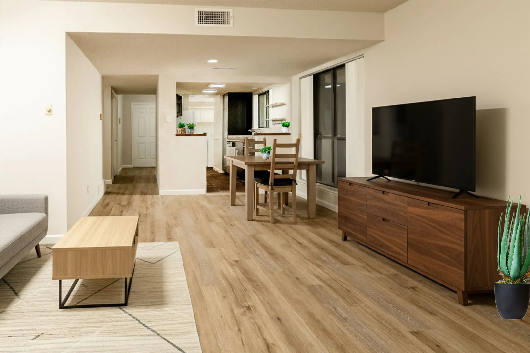 Open-concept living area featuring wood-finish flooring, recessed lighting, and a neutral color palette