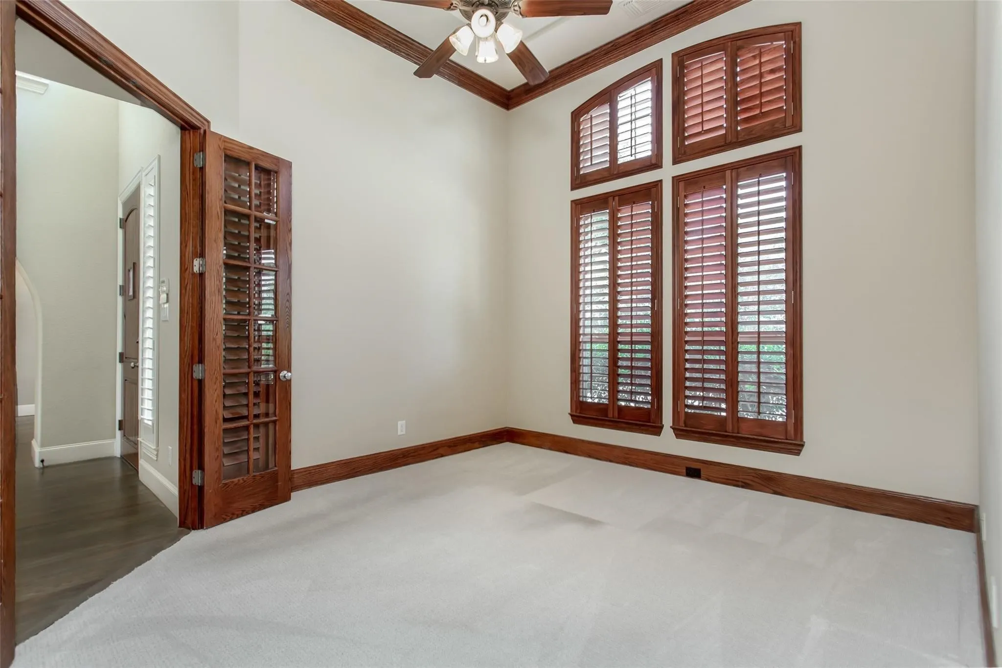 Interior space featuring vaulted ceilings, light-toned carpeting, and wood-finish trim