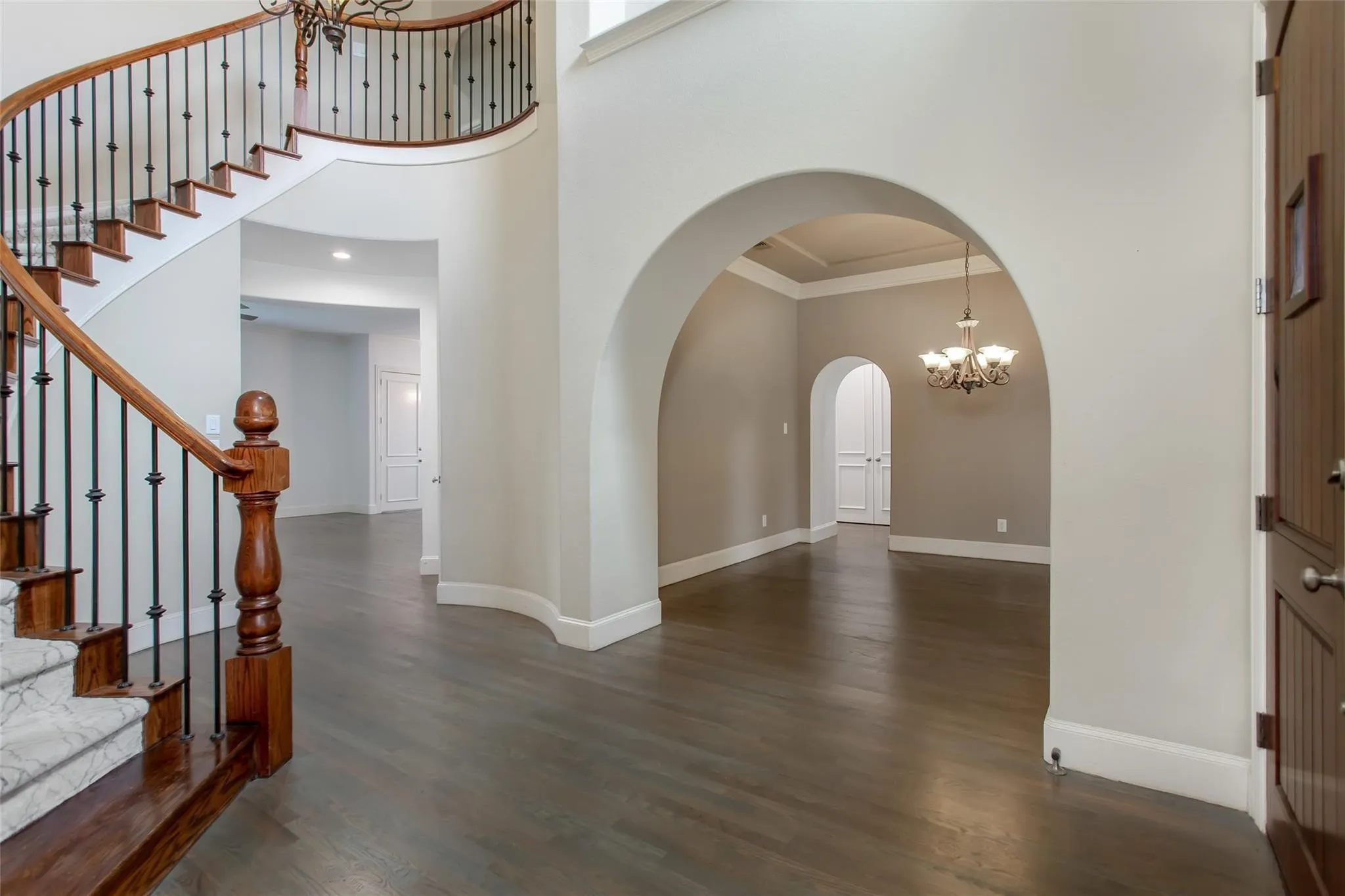 Grand entry foyer featuring a curved staircase with wood treads and wrought iron balusters