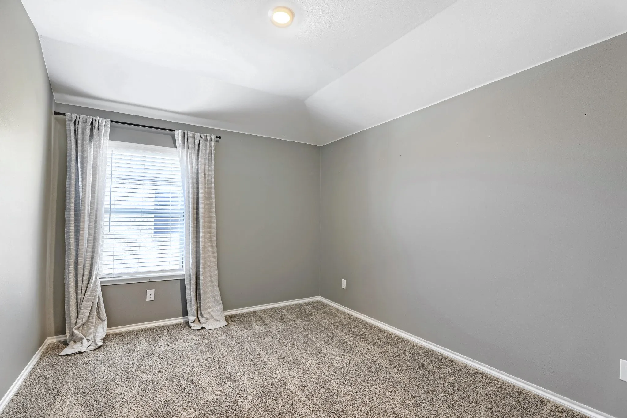 Wall-to-wall carpeting, recessed ceiling lighting, and a window with blinds