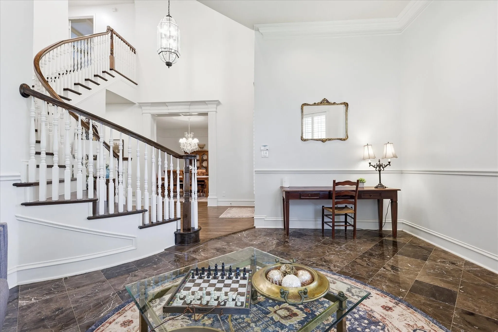Large entry foyer with a curved hardwood stairway. This is a front parlor area.