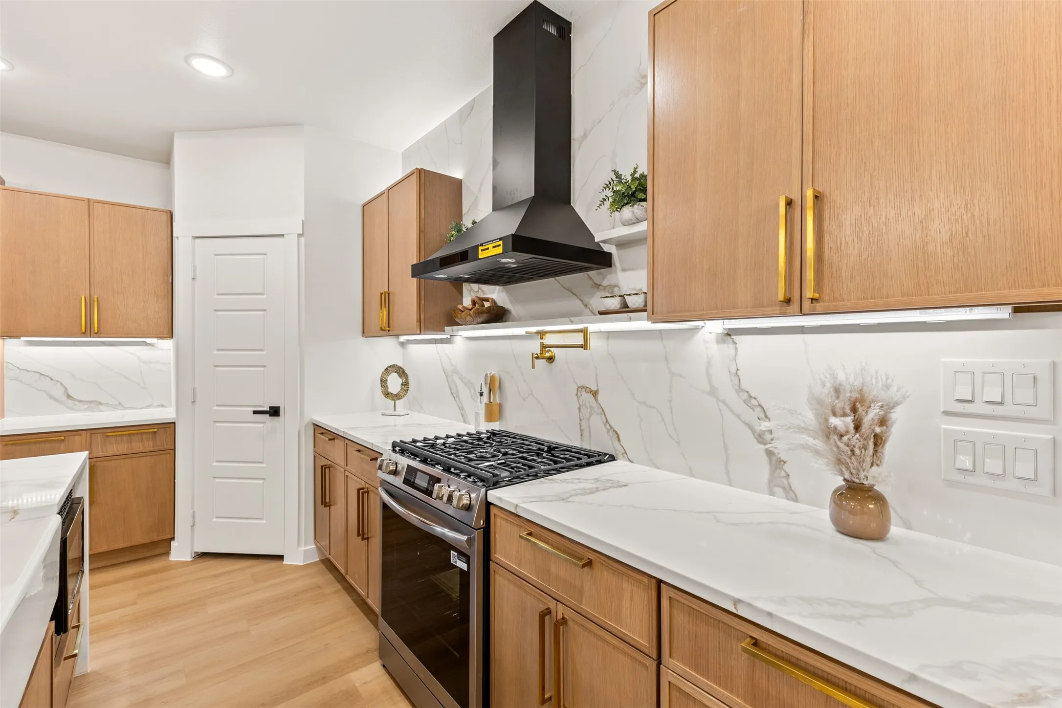 Modern kitchen featuring wood-finish cabinetry with gold-tone hardware