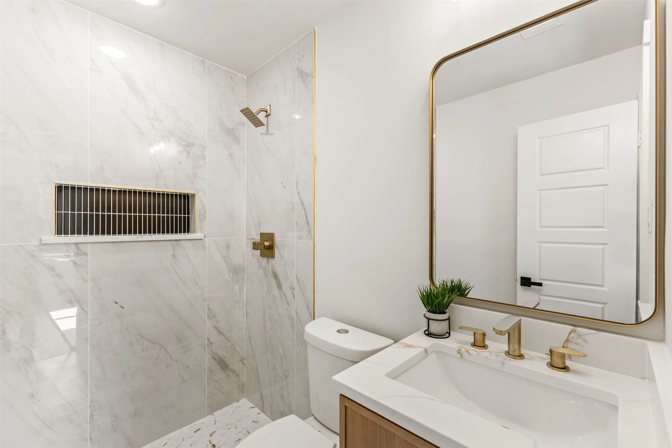 Contemporary bathroom featuring a wood-finish vanity with an integrated rectangular sink and gold-tone fixtures