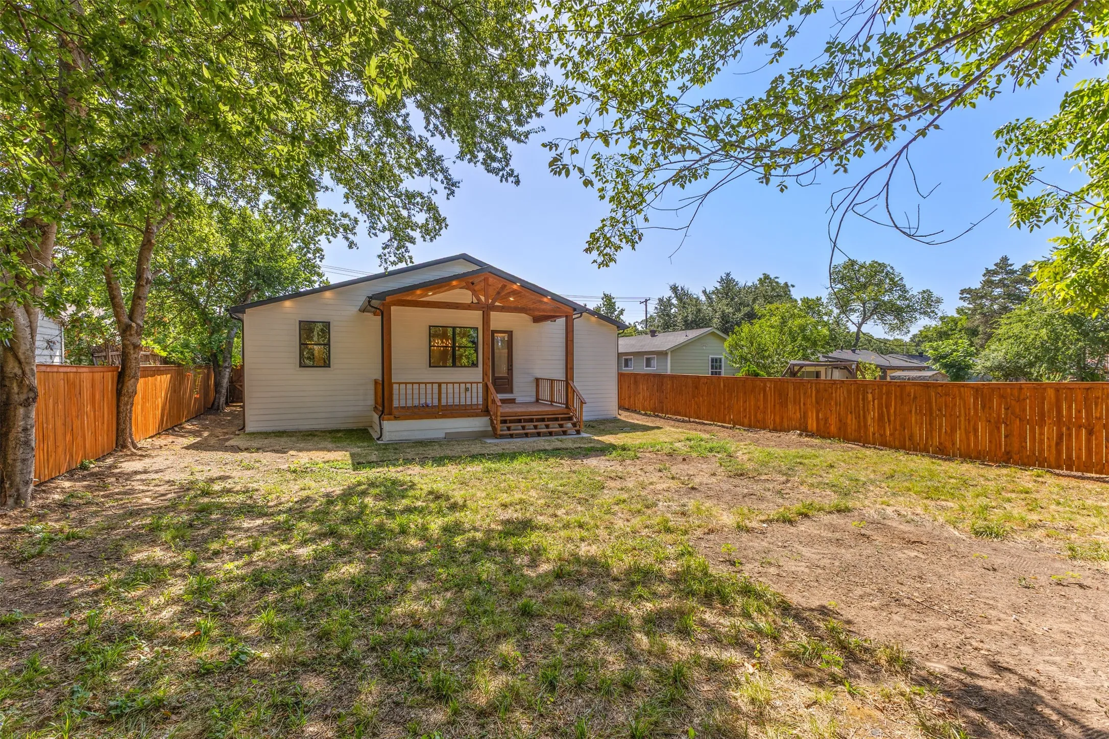 Expansive rear yard featuring a newly installed wooden privacy fence