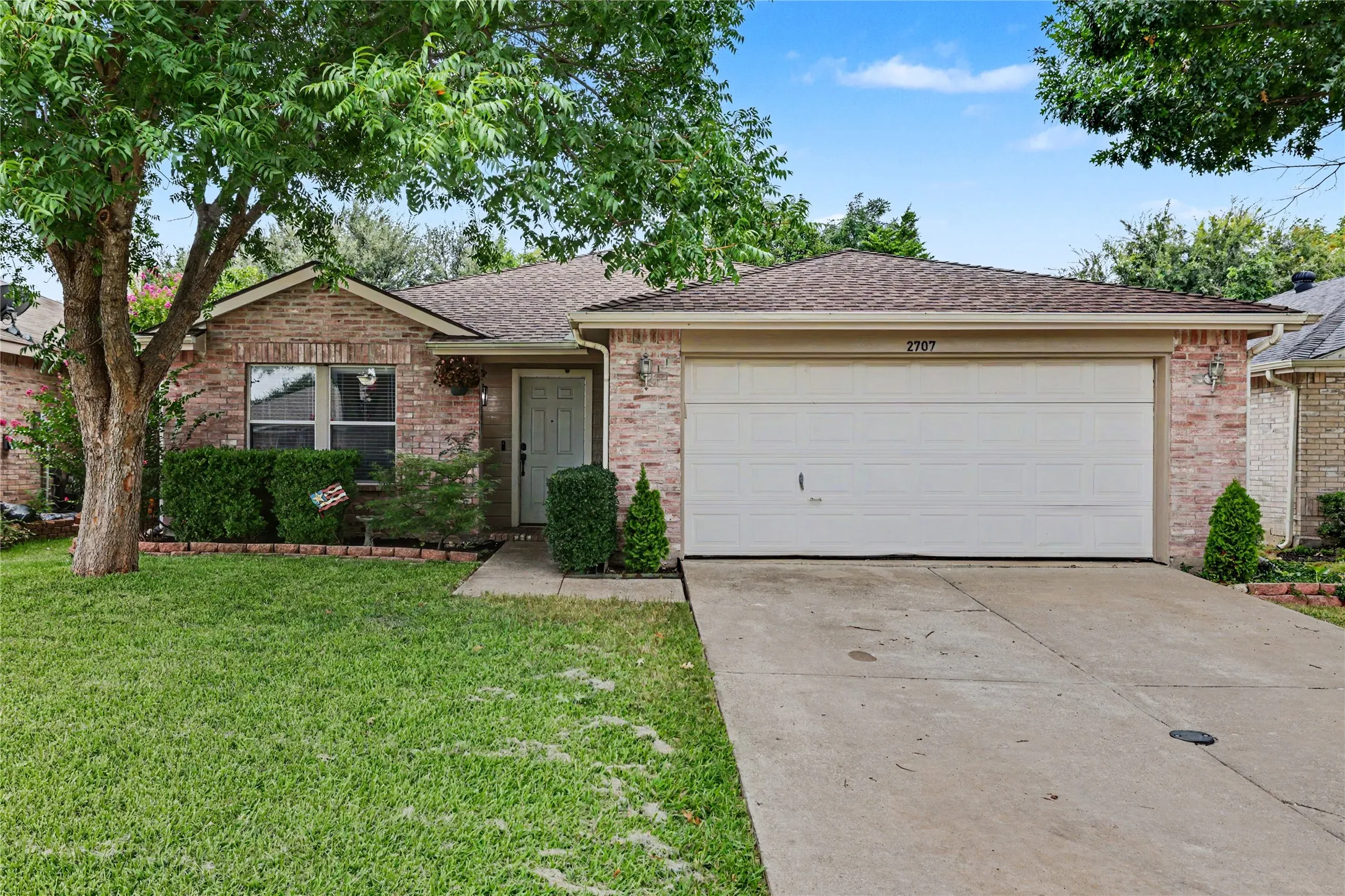 Brick veneer exterior with an attached two-car garage and concrete driveway