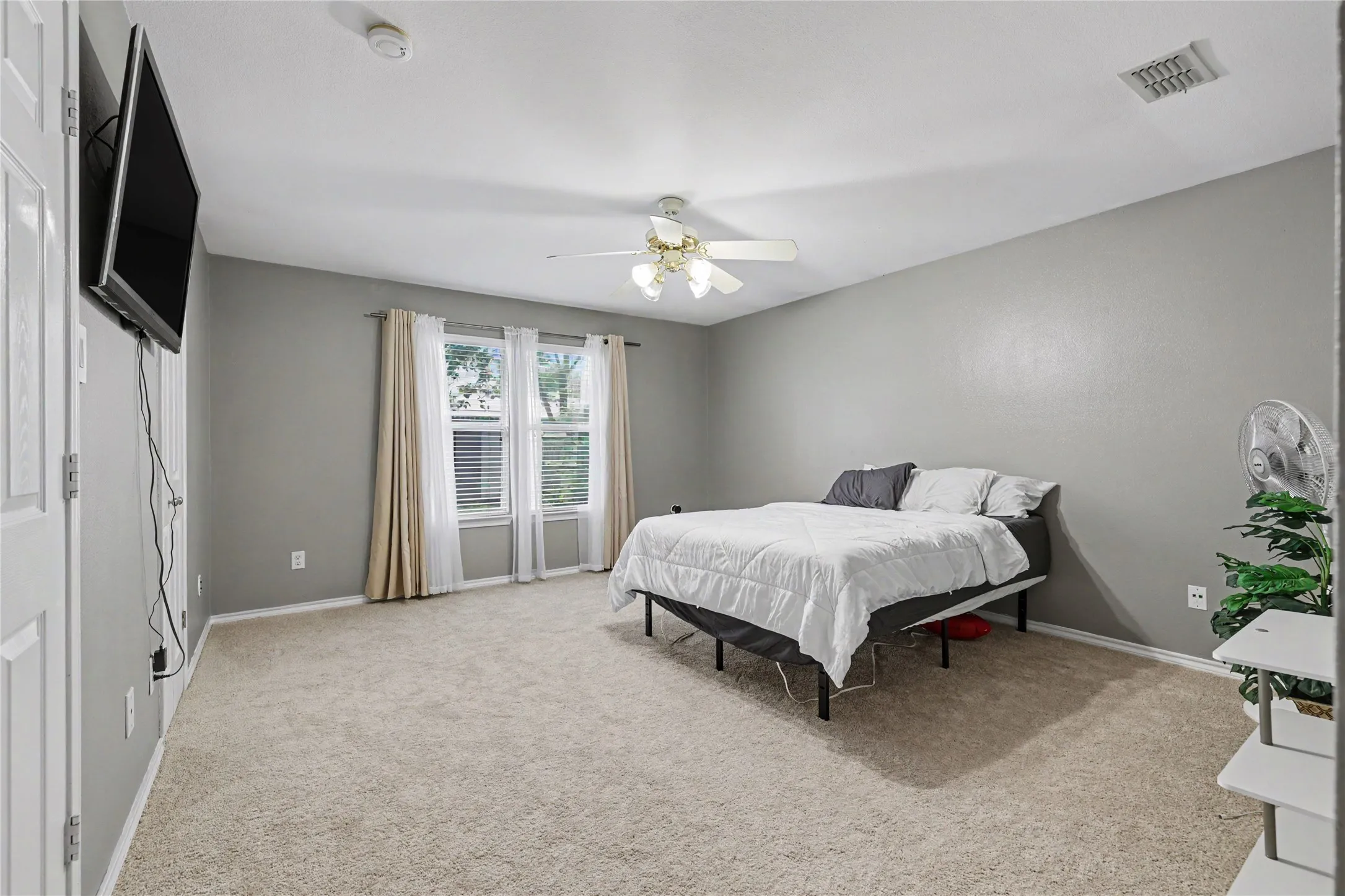 Spacious room featuring neutral carpeting and light gray walls