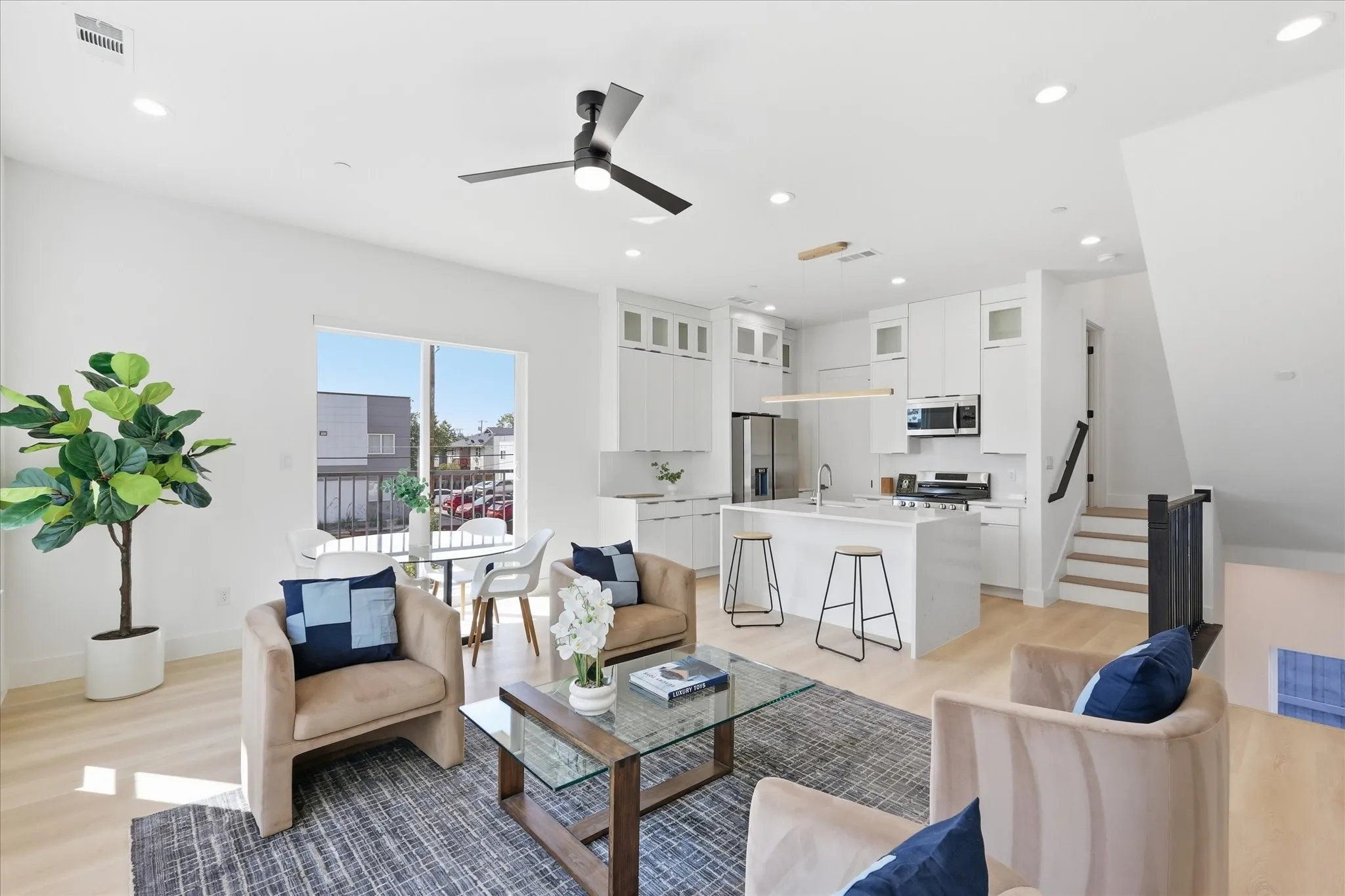 Open-concept living space featuring light wood-finish flooring, recessed lighting, and a modern ceiling fan