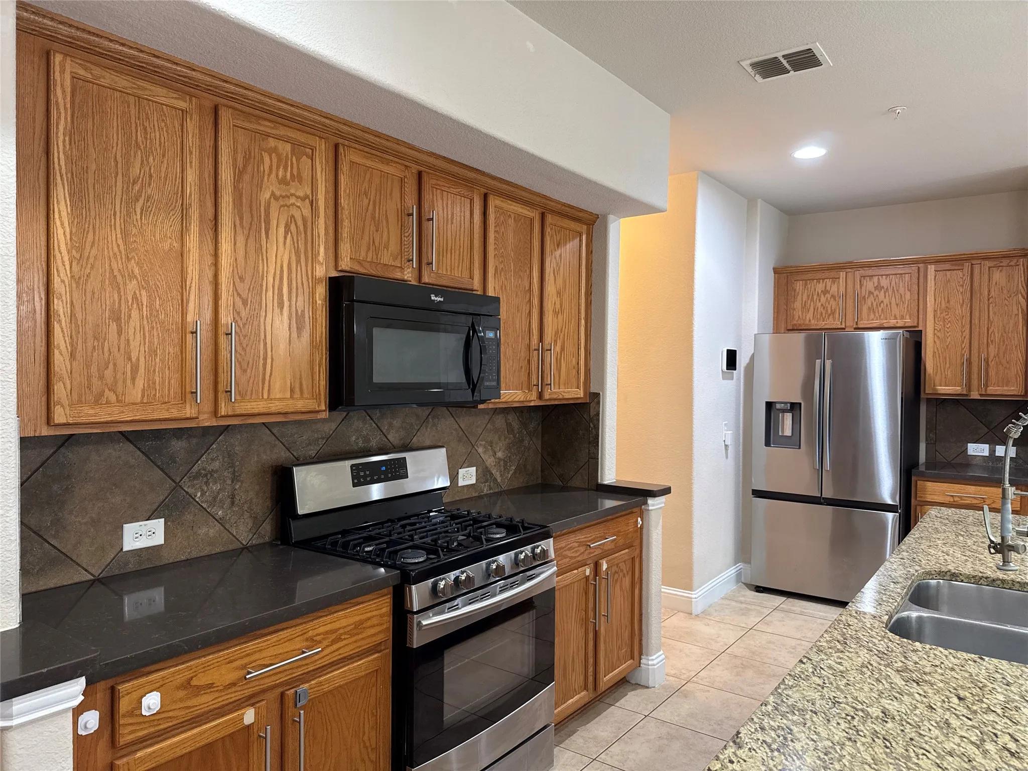Kitchen featuring wood cabinetry, stainless steel appliances, and a gas range