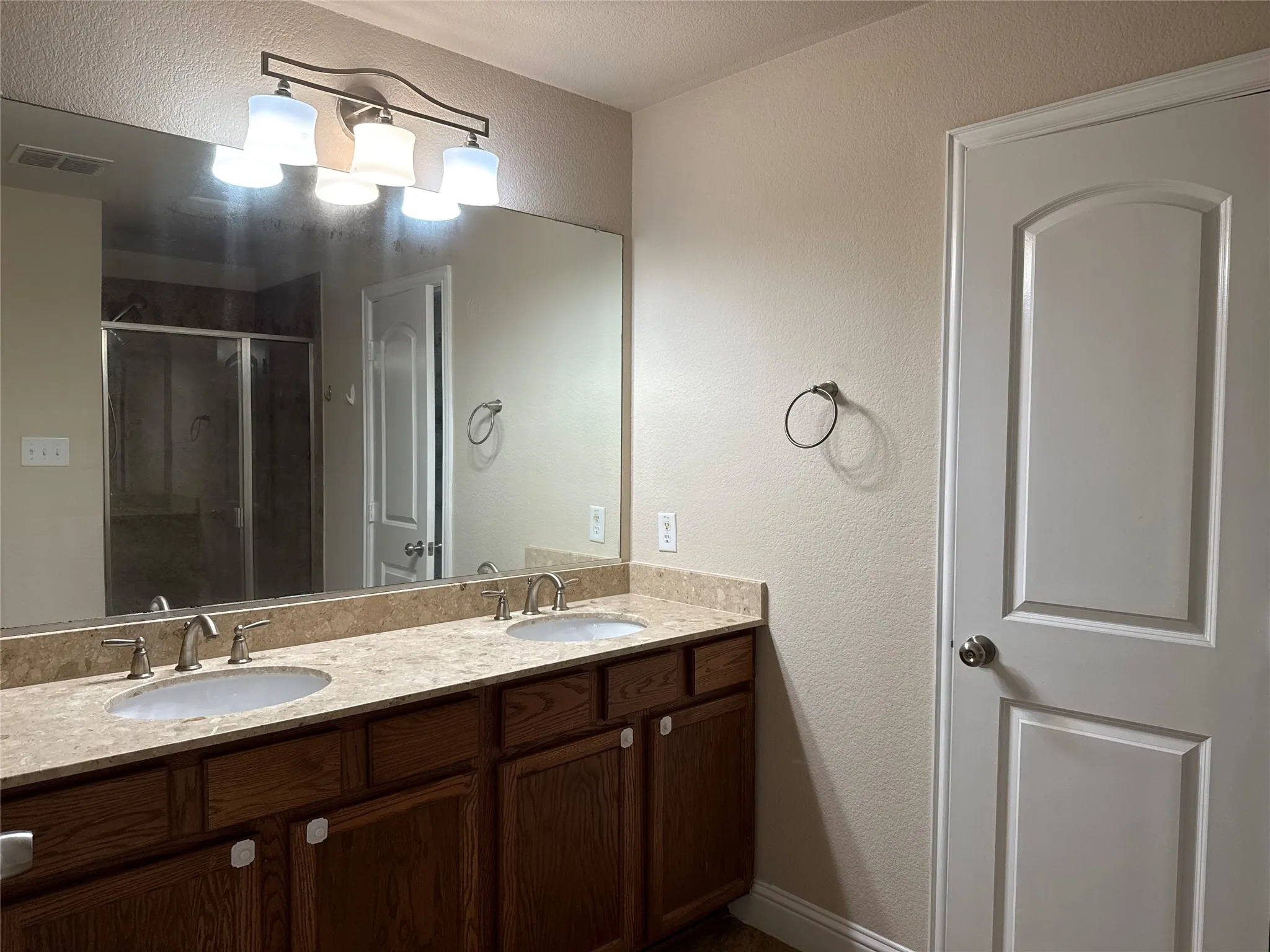 Dual vanity with undermount sinks, bronze faucets, and a light-toned countertop