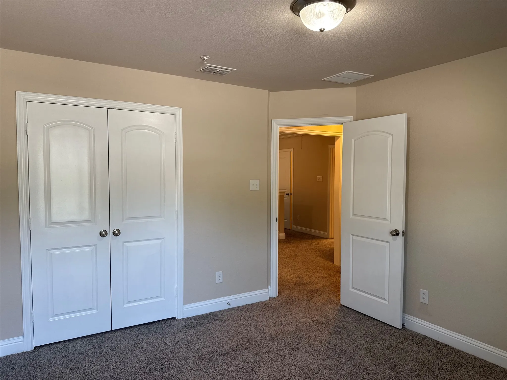 Neutral tone wall paint, textured carpet flooring, white trim, recessed lighting, and a semi-flush mount ceiling fixture