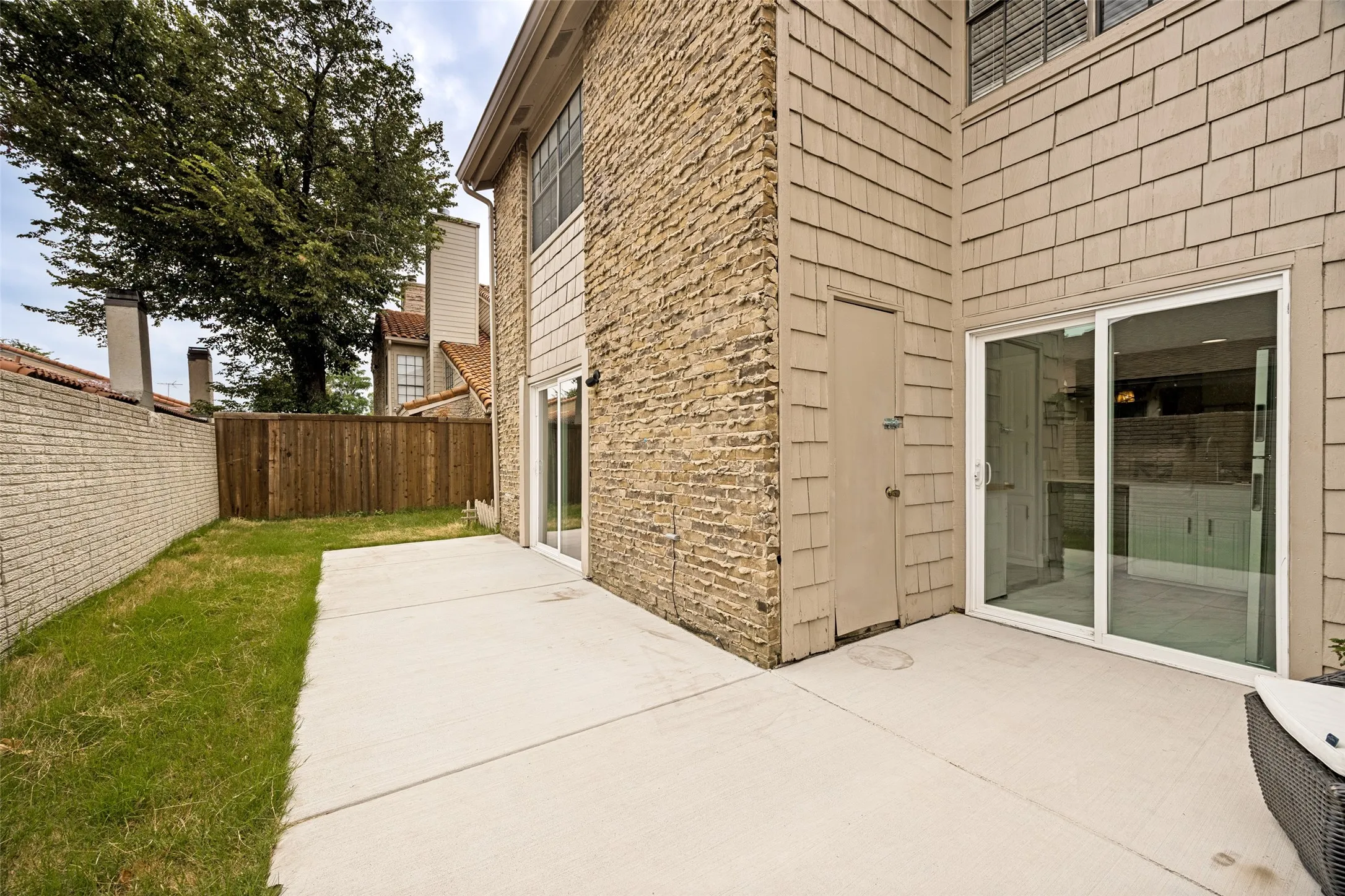 Private outdoor patio featuring concrete paving, a fenced yard, and direct access through a sliding glass door