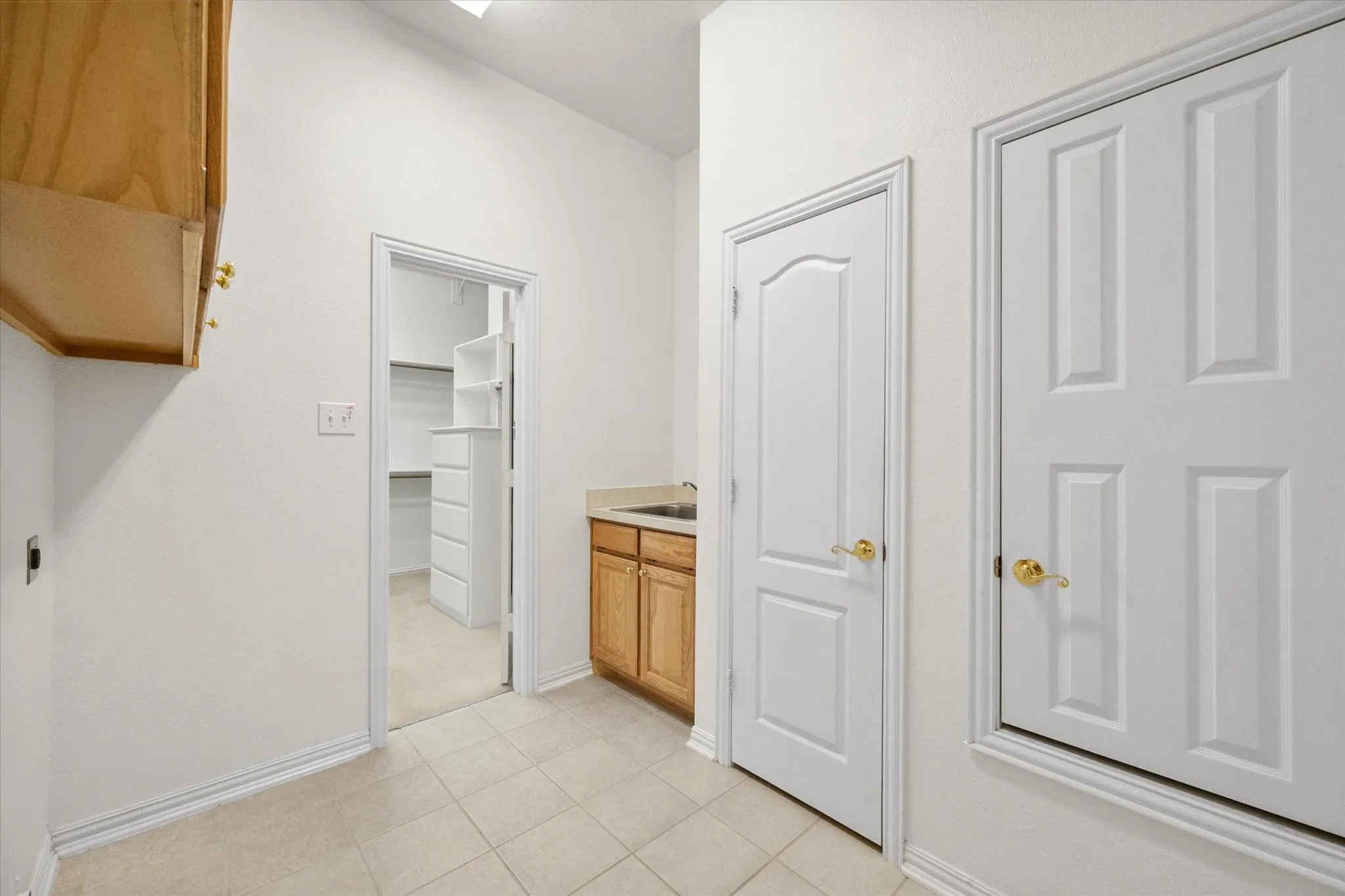 Large laundry room with closet, cabinets and sink