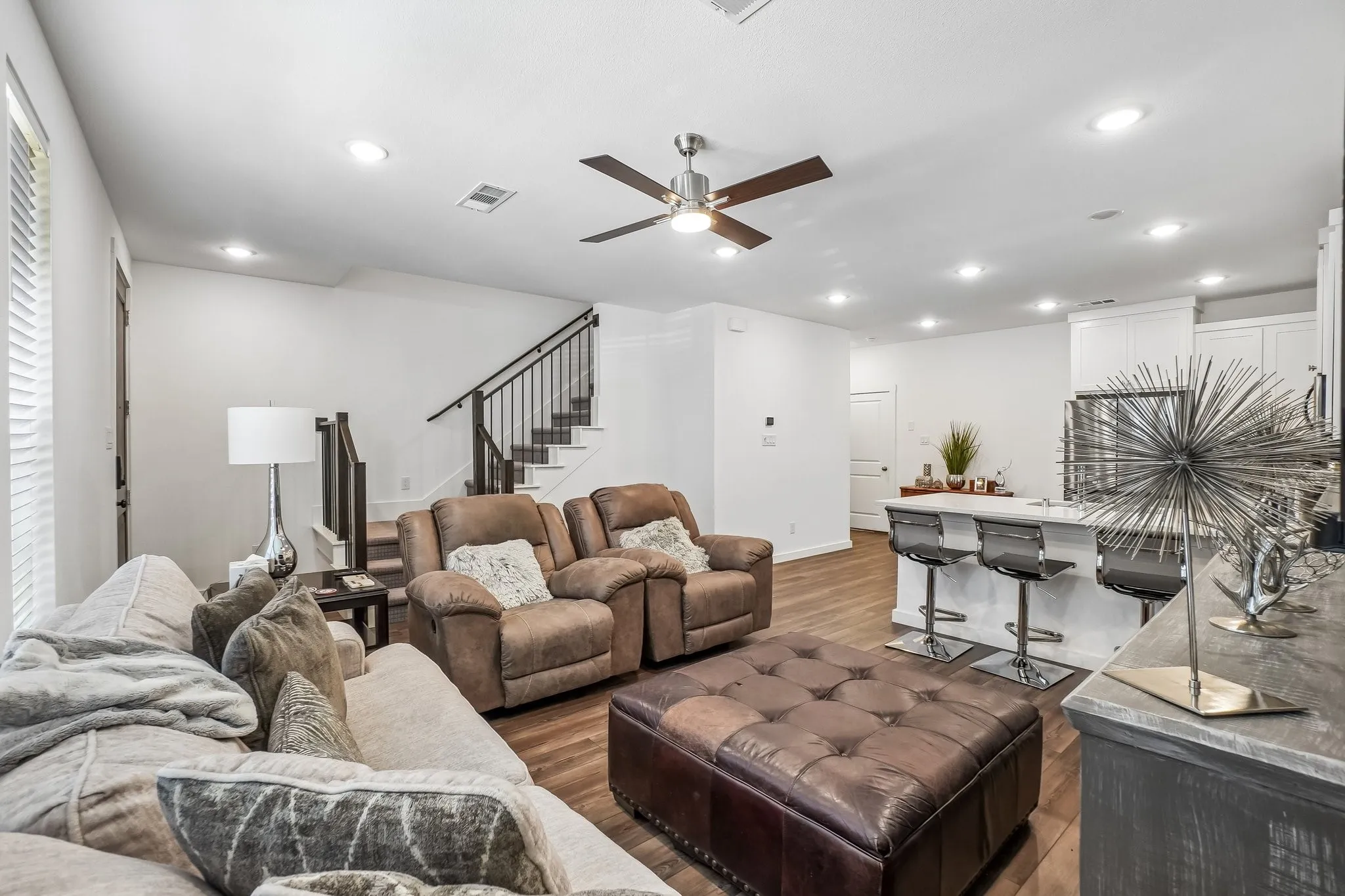 Bright living area featuring wood-finish flooring, recessed lighting, and a ceiling fan