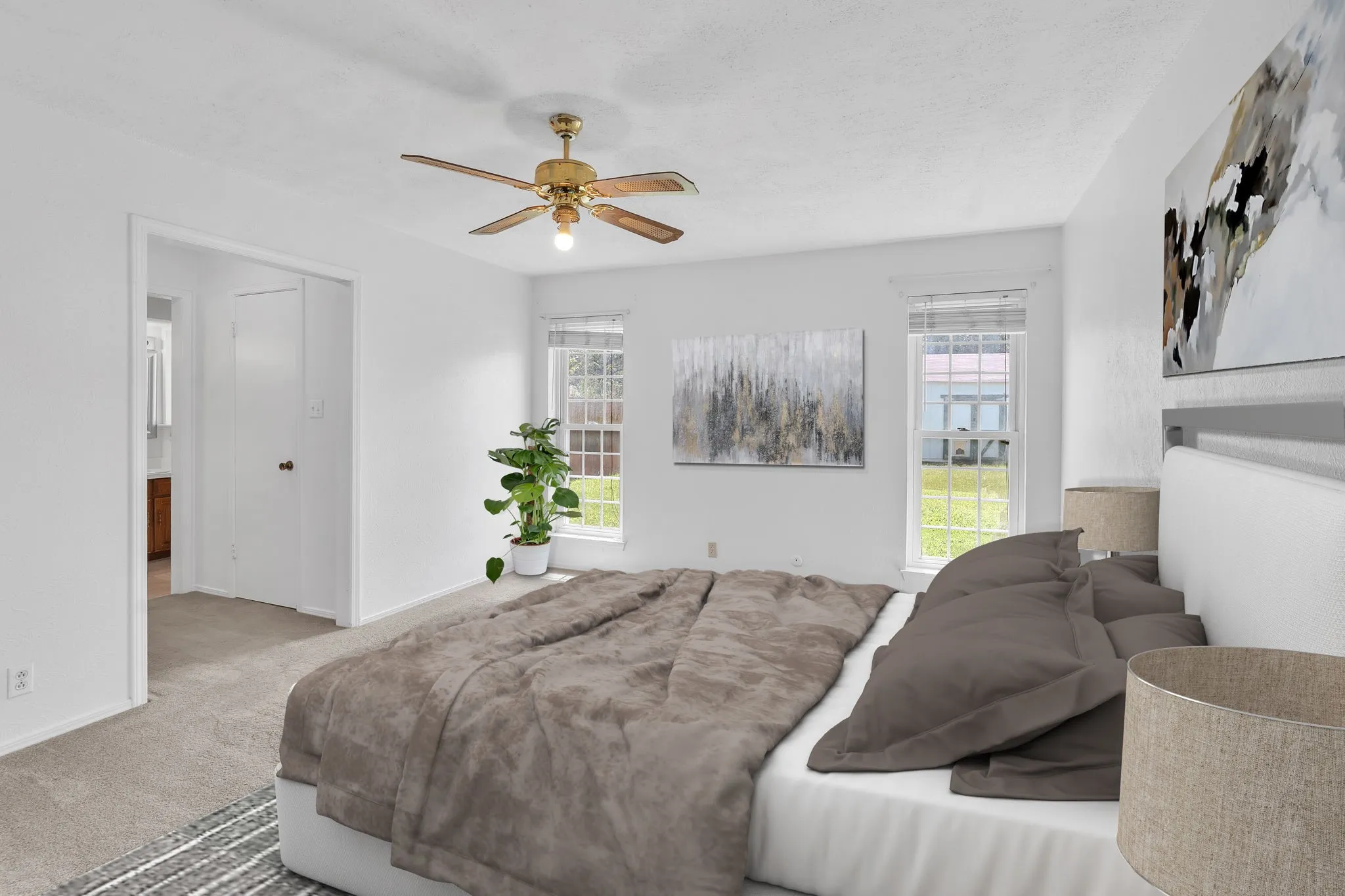 Carpeted bedroom with a ceiling fan, two windows, and a doorway leading to another room