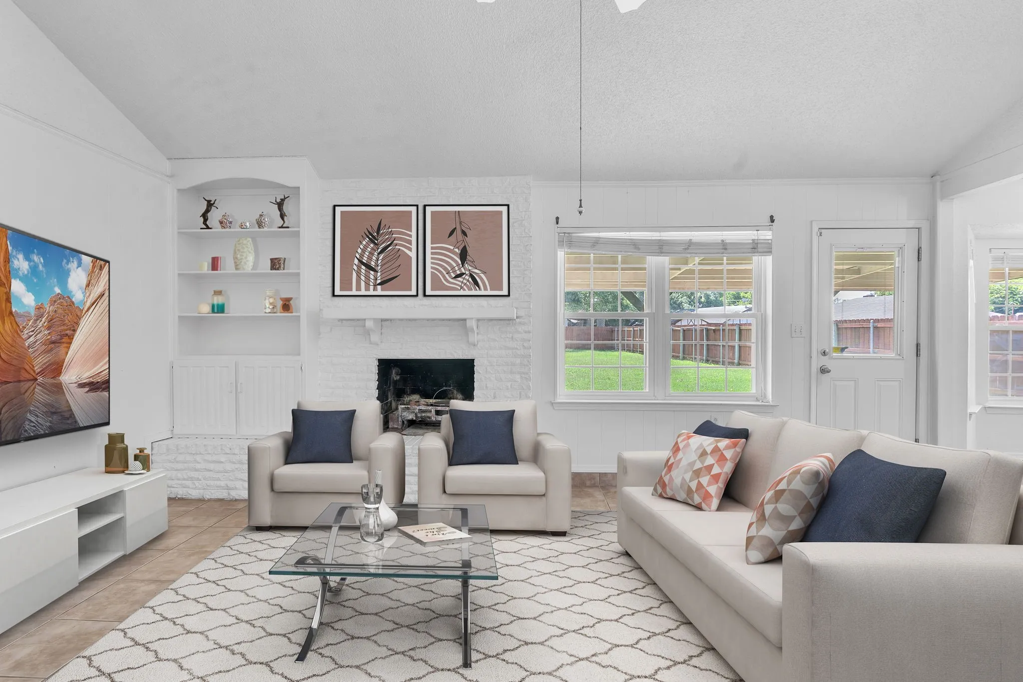 Living area featuring a brick fireplace, built-in shelving, vaulted ceilings, tile flooring, and abundant natural light