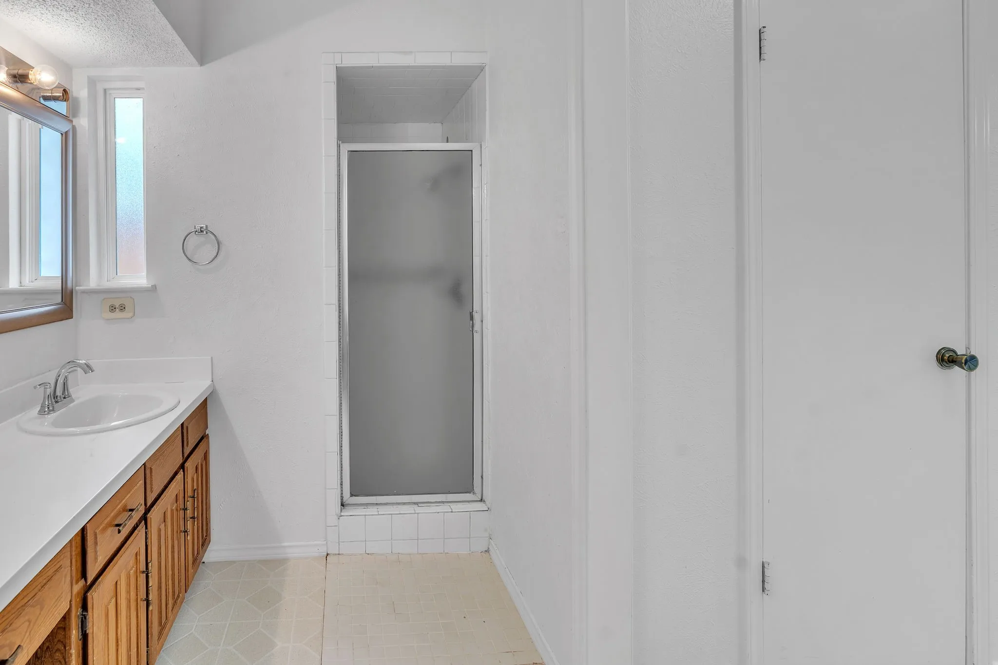 Bathroom vanity featuring a single basin sink and wood-finish cabinetry