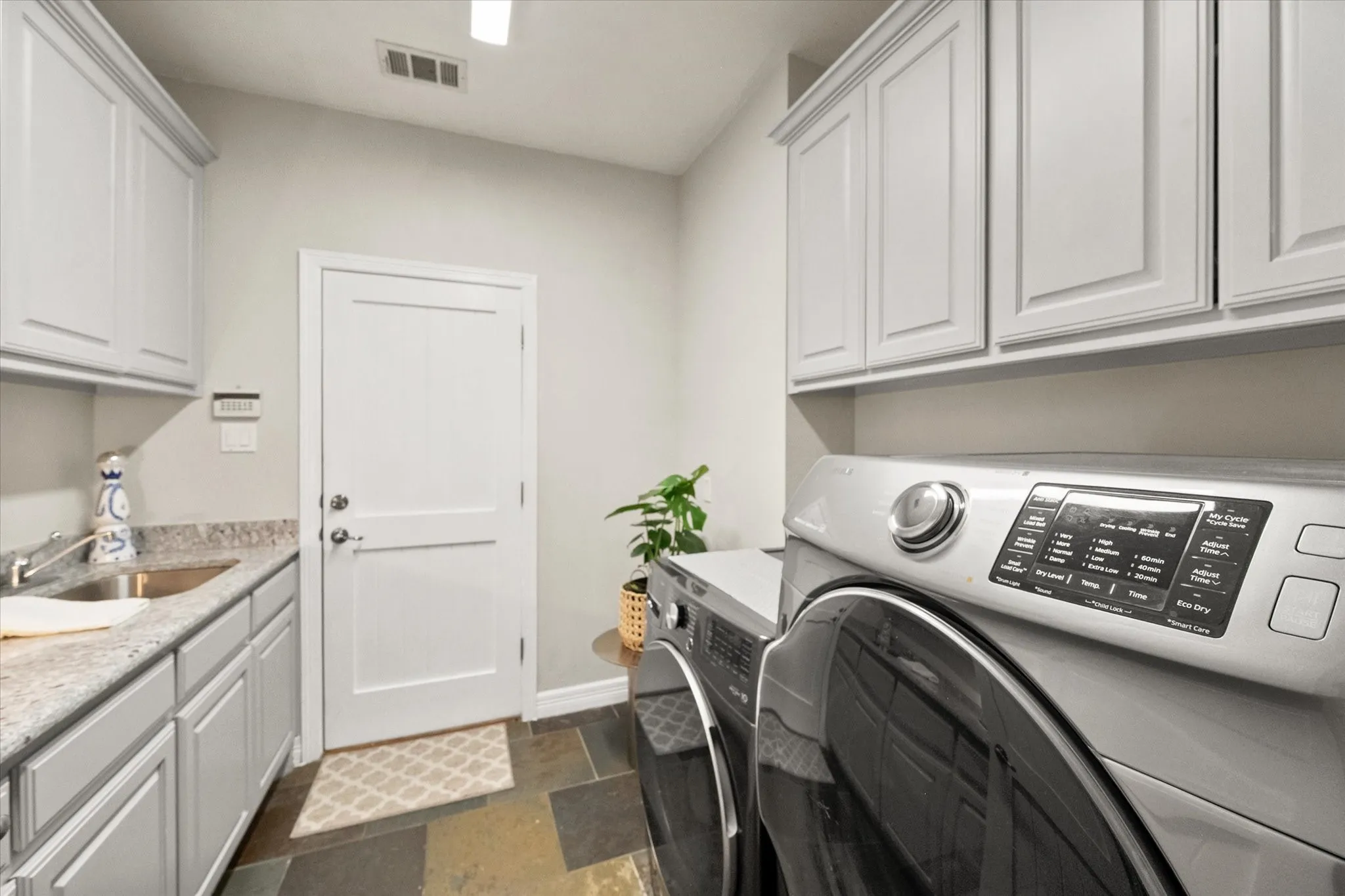 Laundry room with granite countertops, sink and lots of cabinets