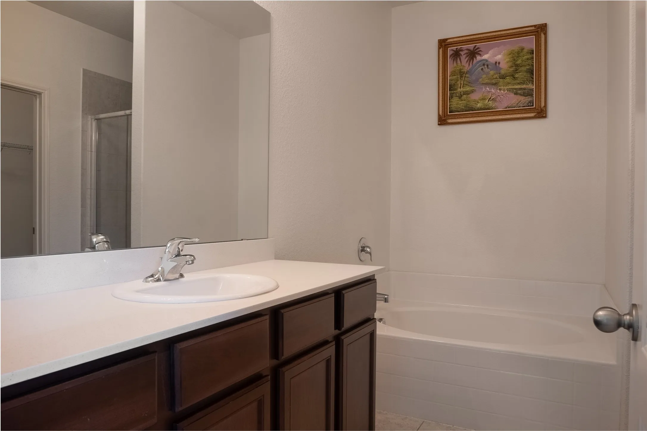 Bathroom with vanity, a relaxing tiled bath, and tile floors